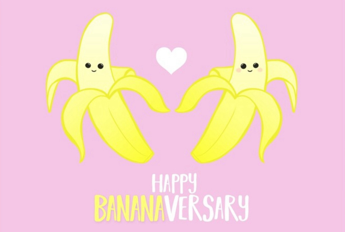 Two smiling bananas with a little heart between them on a pink background. At the bottom is says “Happy Bananaversary”