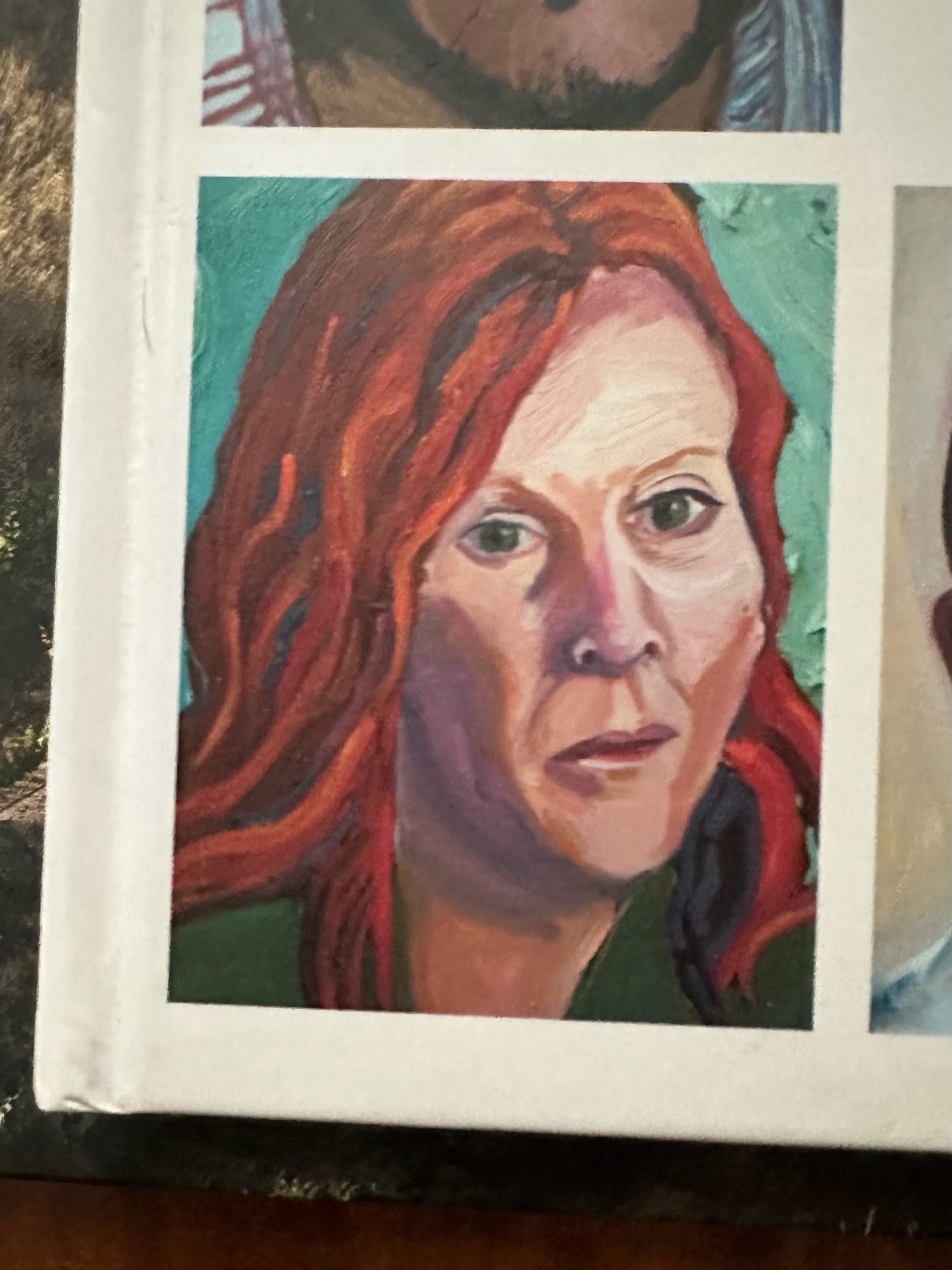 A painting by George W Bush of a possibly femme type person . It is very bad, both technically and artistically and it is impossible for me to tell who it’s supposed to be. It has red hair with orange highlights, face that is possibly shaded, but makes it look kind of sunken in and green eyes that match her green shirt. She truly looks as if he was trying to paint Amy Schumer, but then changed midstream because her face was too narrow and tried to do Tori Amos, and neither of those concepts succeeded.