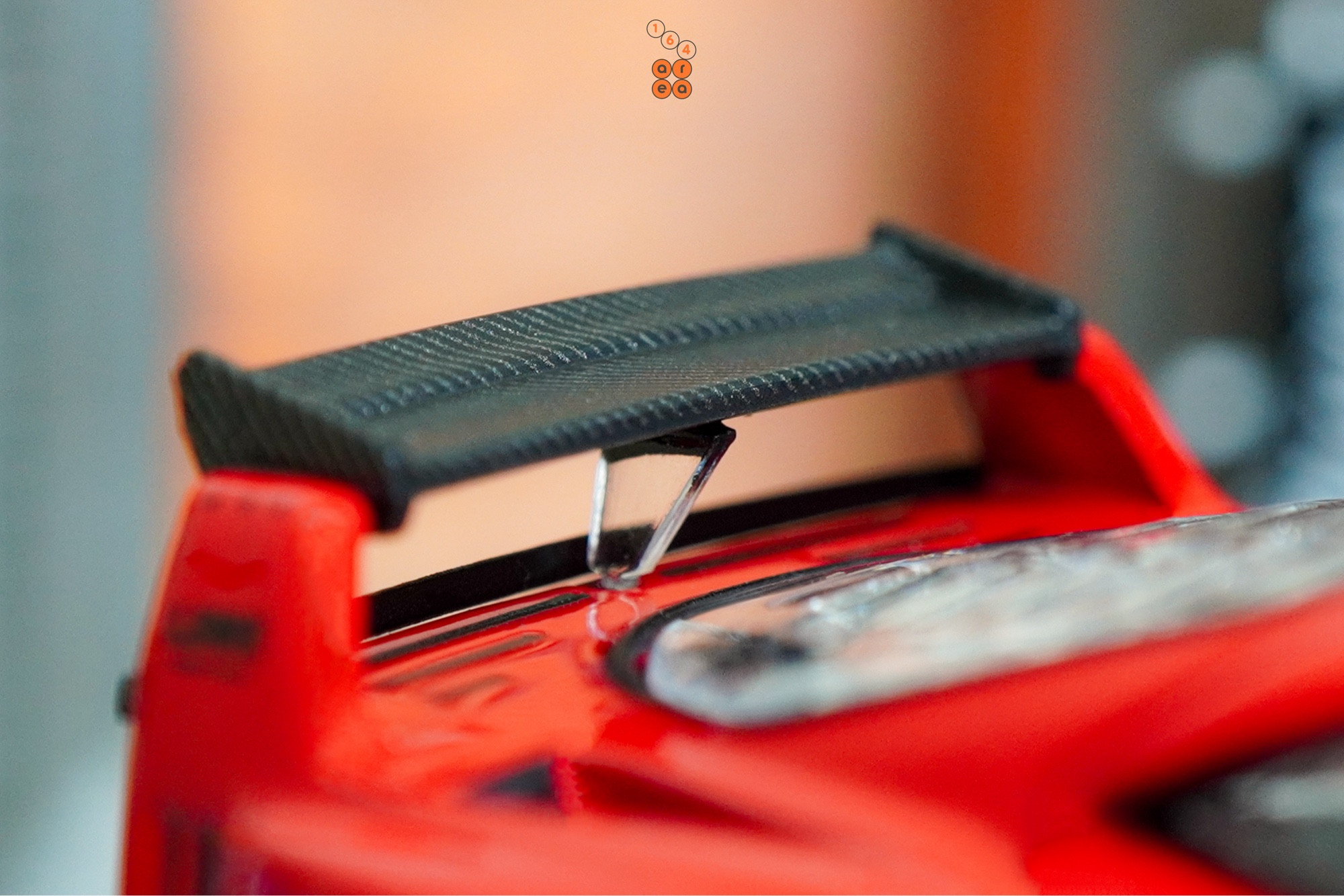 A close-up shot of a red LB-WORKS Ferrari F40 by INNO64 in 1:64 scale on AREA 164