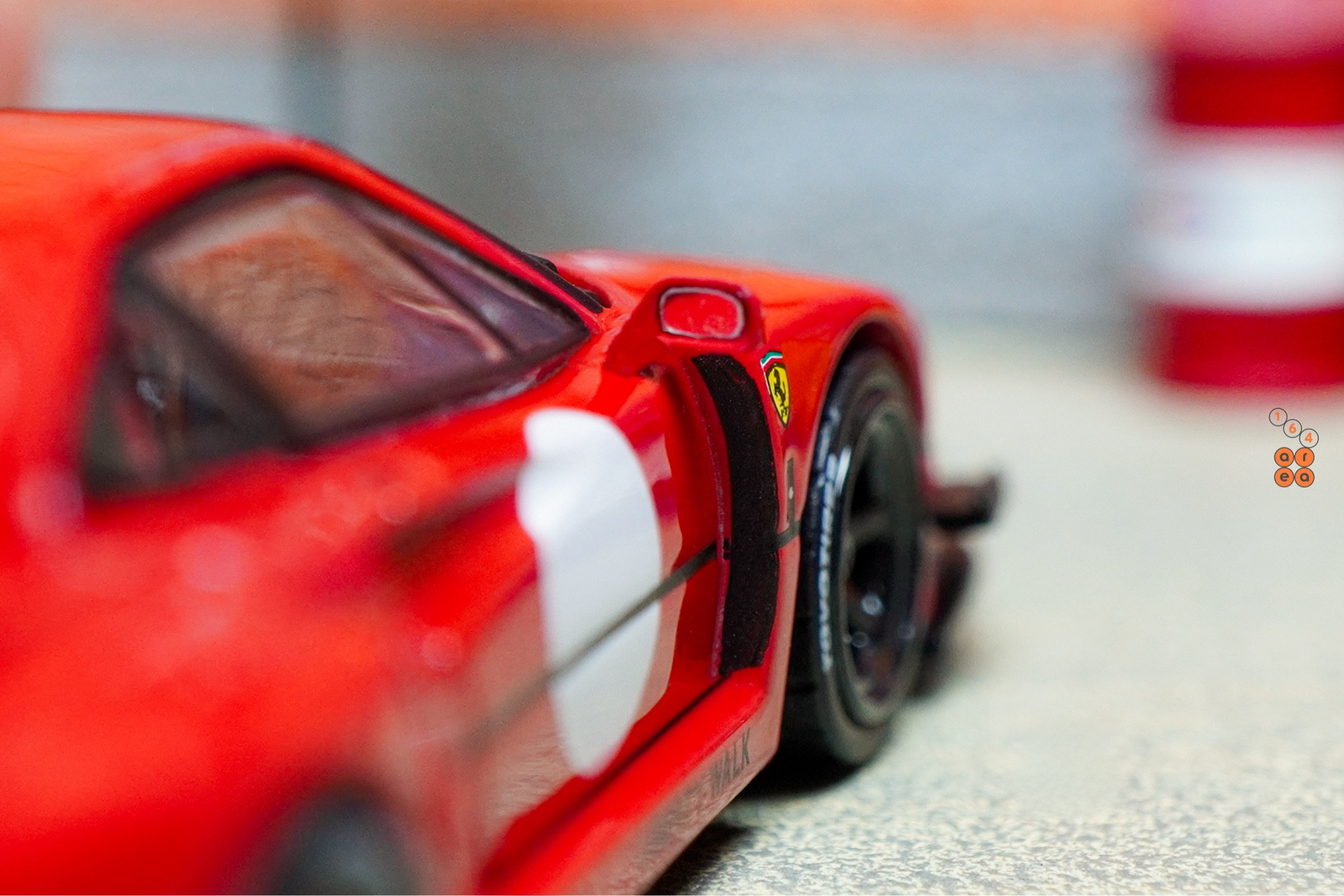 A close-up shot of a red LB-WORKS Ferrari F40 by INNO64 in 1:64 scale on AREA 164