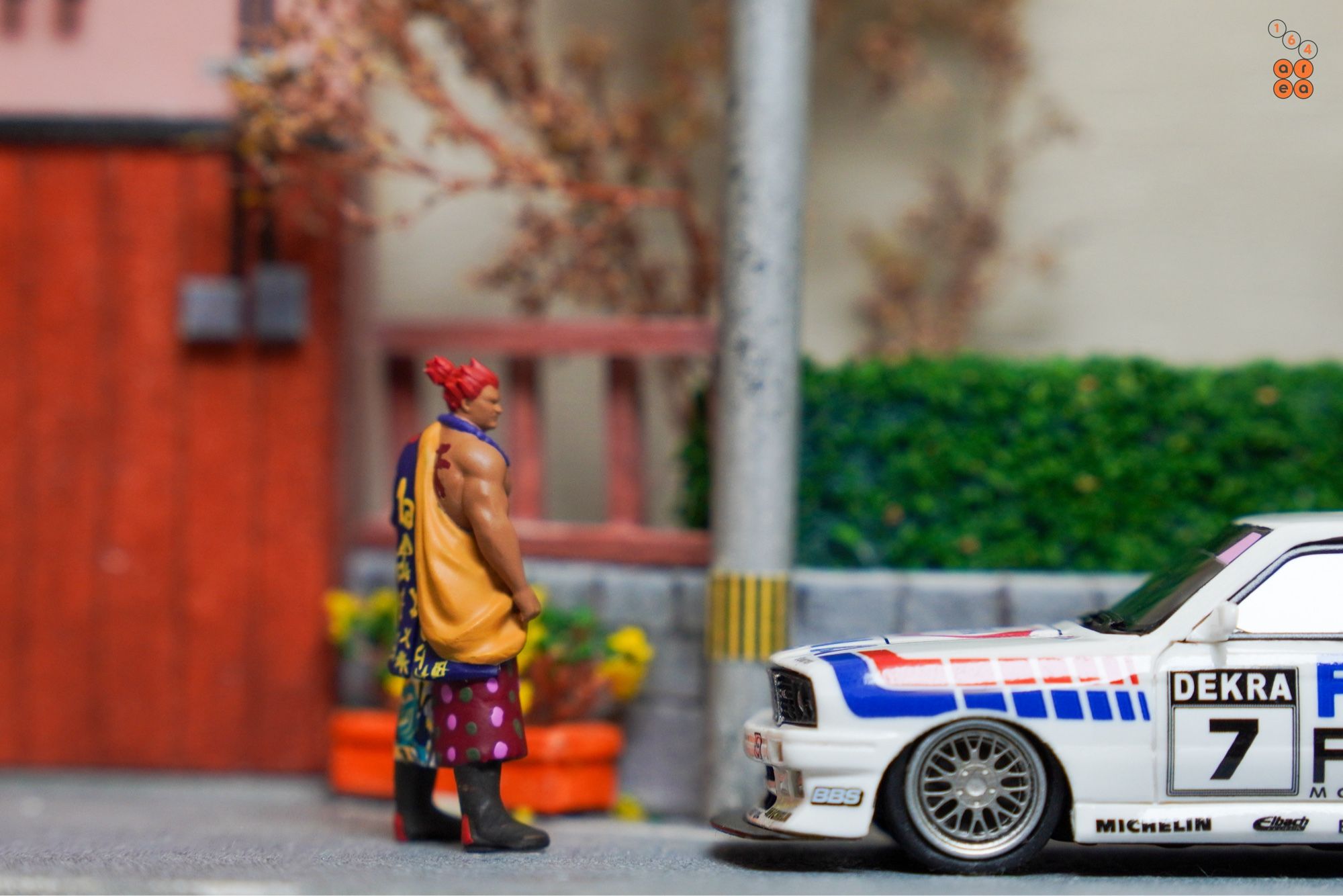 A big guy turn to face a BMW E30 M3, FINA First Oil livery by ScaleMini in 1:64 scale with 1:64 figure on AREA 164