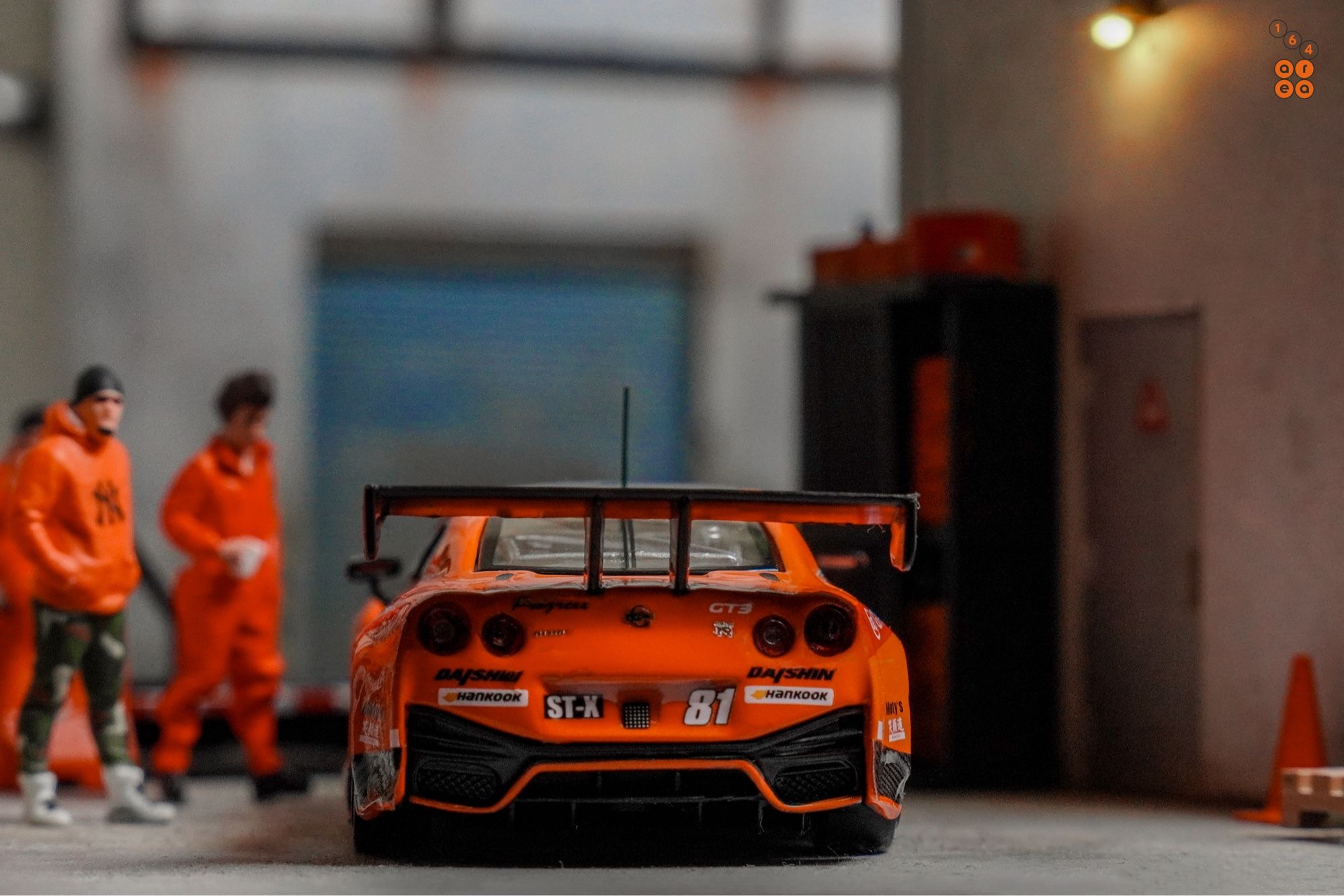 A rear side of Nissan GT-R Nismo GT3, Super Taikyu Series 2021, Fuji 24 hours 2021, No. 81 Winner by Tarmac Works in 1:64 scale with 1:64 figure on AREA 164