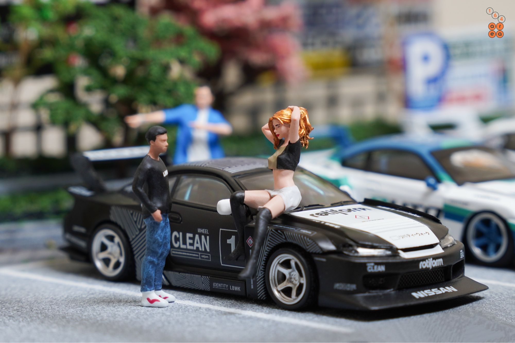 A guy talk to a sexy girl who sit on a bonnet of LB-Super Silhouette, Nissan Silvia S15 by Time Micro in 1:64 scale with 1:64 figures on AREA 164