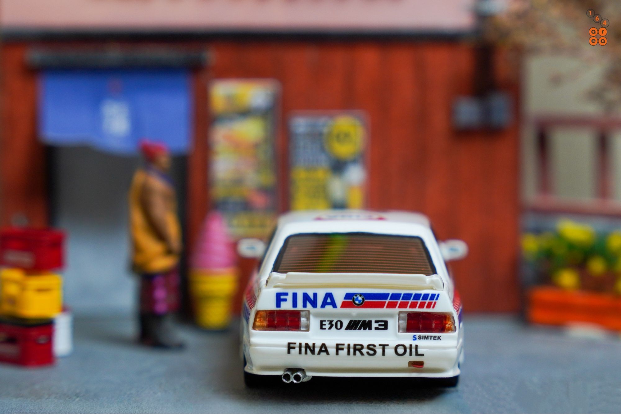 A rear side of BMW E30 M3, FINA First Oil livery by ScaleMini in 1:64 scale with 1:64 figures on AREA 164