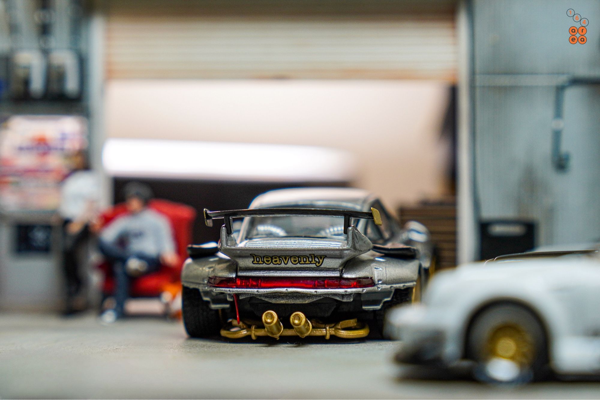 A rear side of Porsche RWB 993 Ram-intra with wording "heavenly" by Street Weapon in 1:64 scale with 1:64 figures on AREA 164