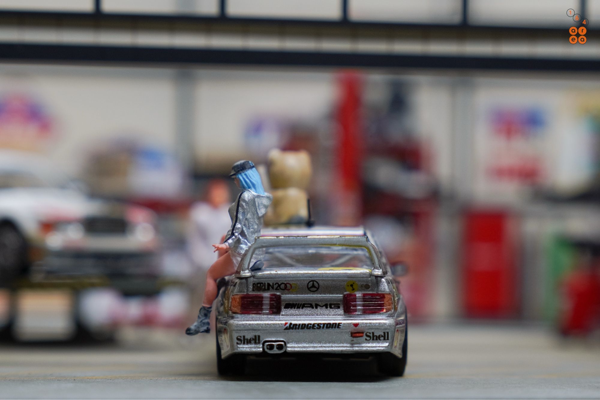 A rear side of Mercedes-Benz 190E 2.5-16 Evolution II, Berlin 2000 livery by Tarmac Works in 1:64 scale with 1:64 figures on AREA 164