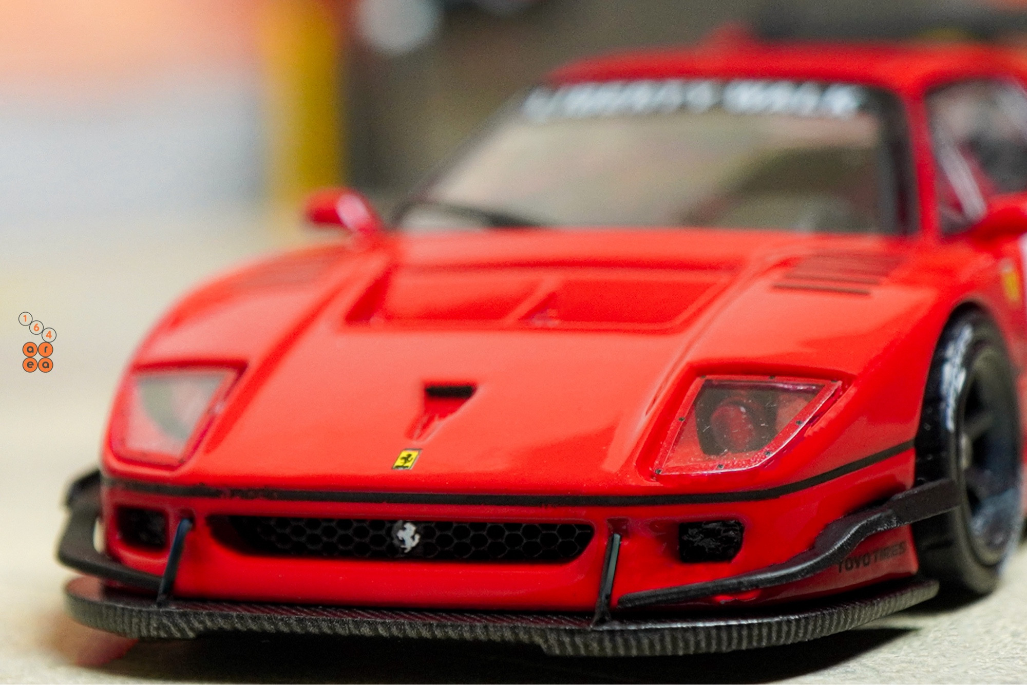 A close-up shot of a red LB-WORKS Ferrari F40 by INNO64 in 1:64 scale on AREA 164