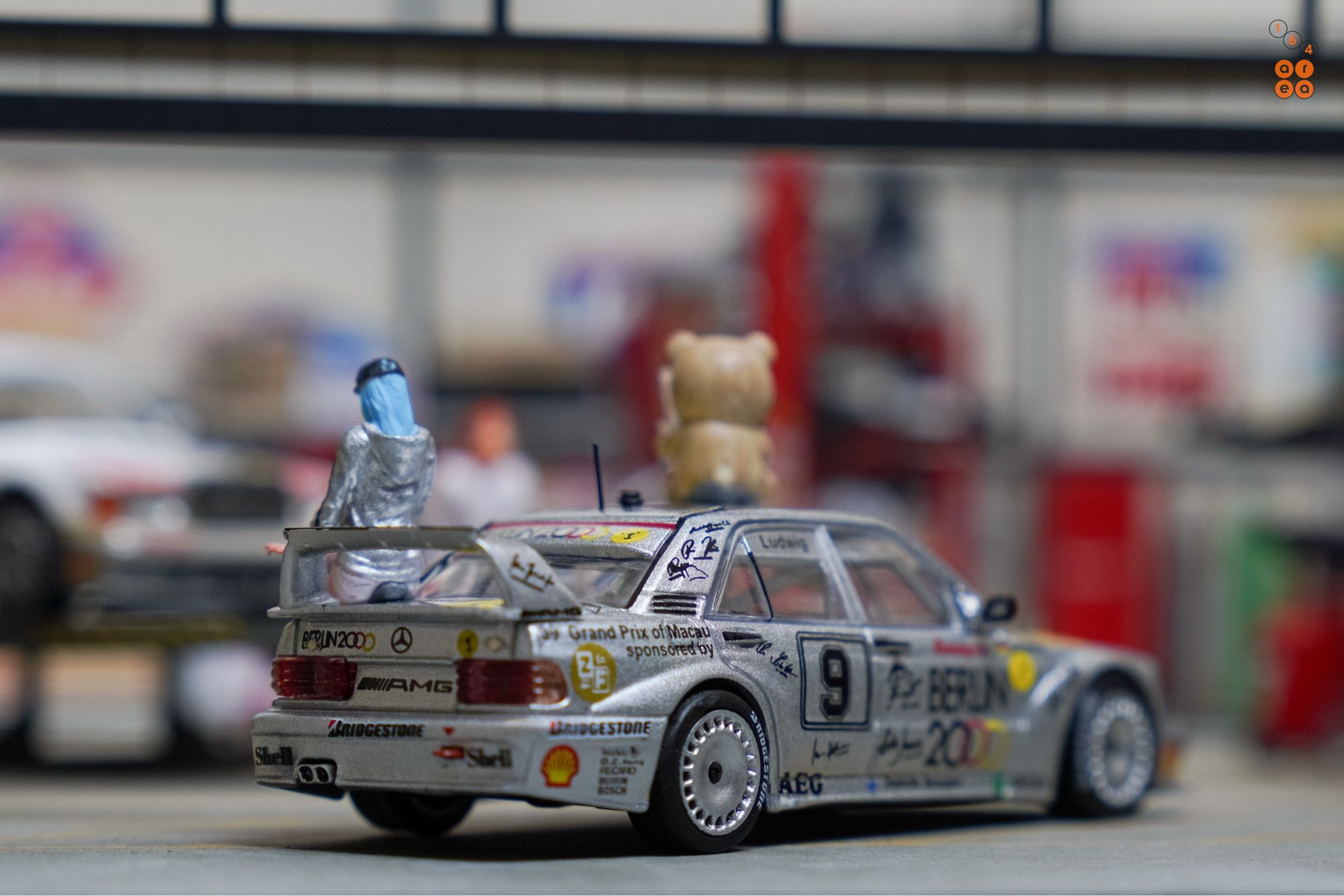 A right side of Mercedes-Benz 190E 2.5-16 Evolution II, Berlin 2000 livery by Tarmac Works in 1:64 scale with 1:64 figures on AREA 164