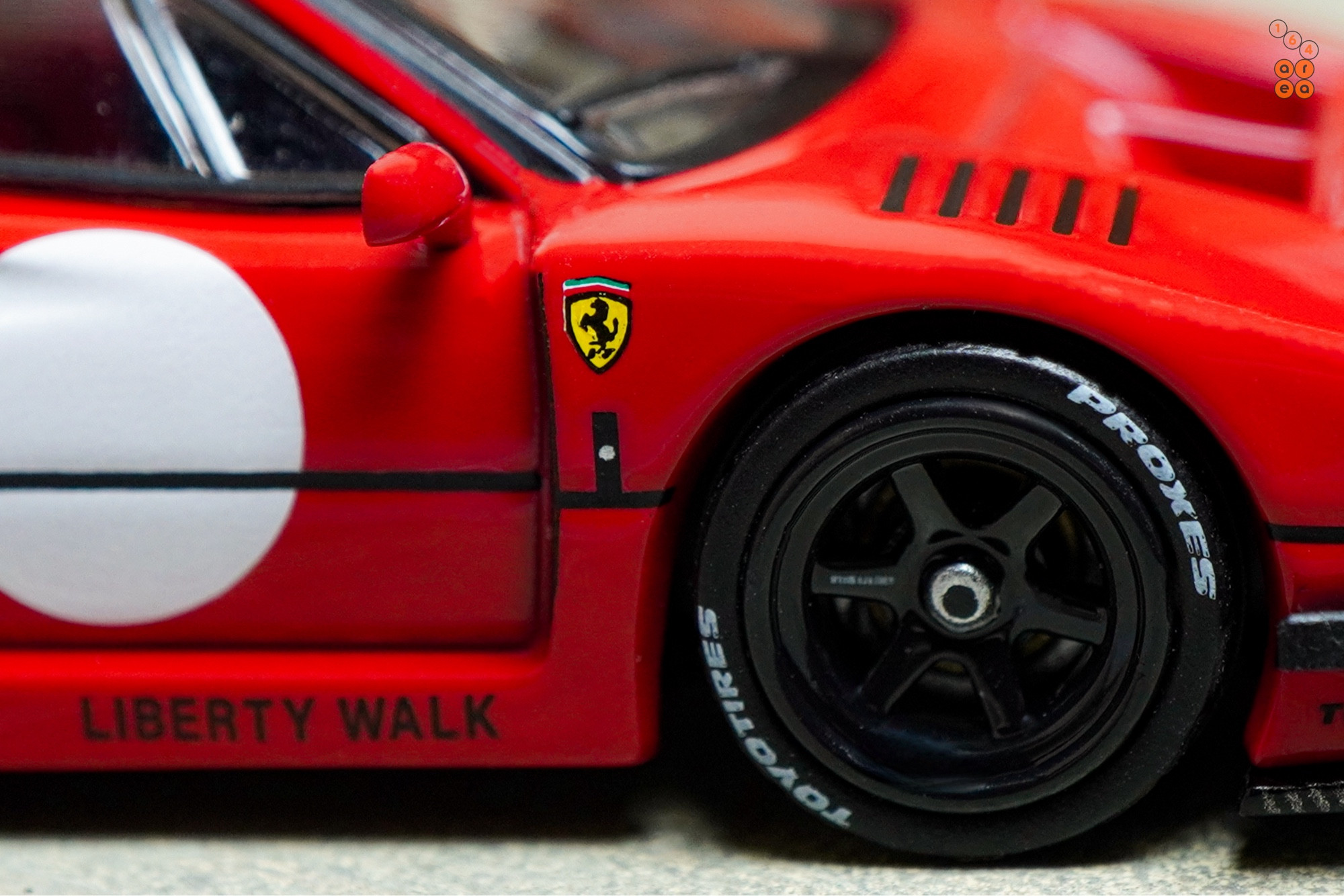 A close-up shot of a red LB-WORKS Ferrari F40 by INNO64 in 1:64 scale on AREA 164