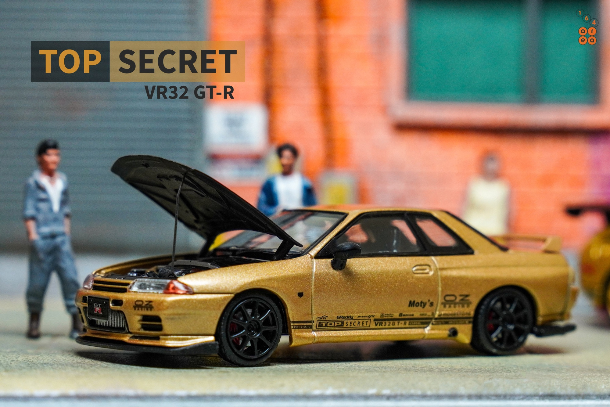 A left side of Nissan Skyline GT-R VR32 Top Secret Gold by Facal Horizon in 1:64 scale with 1:64 figure on AREA 164