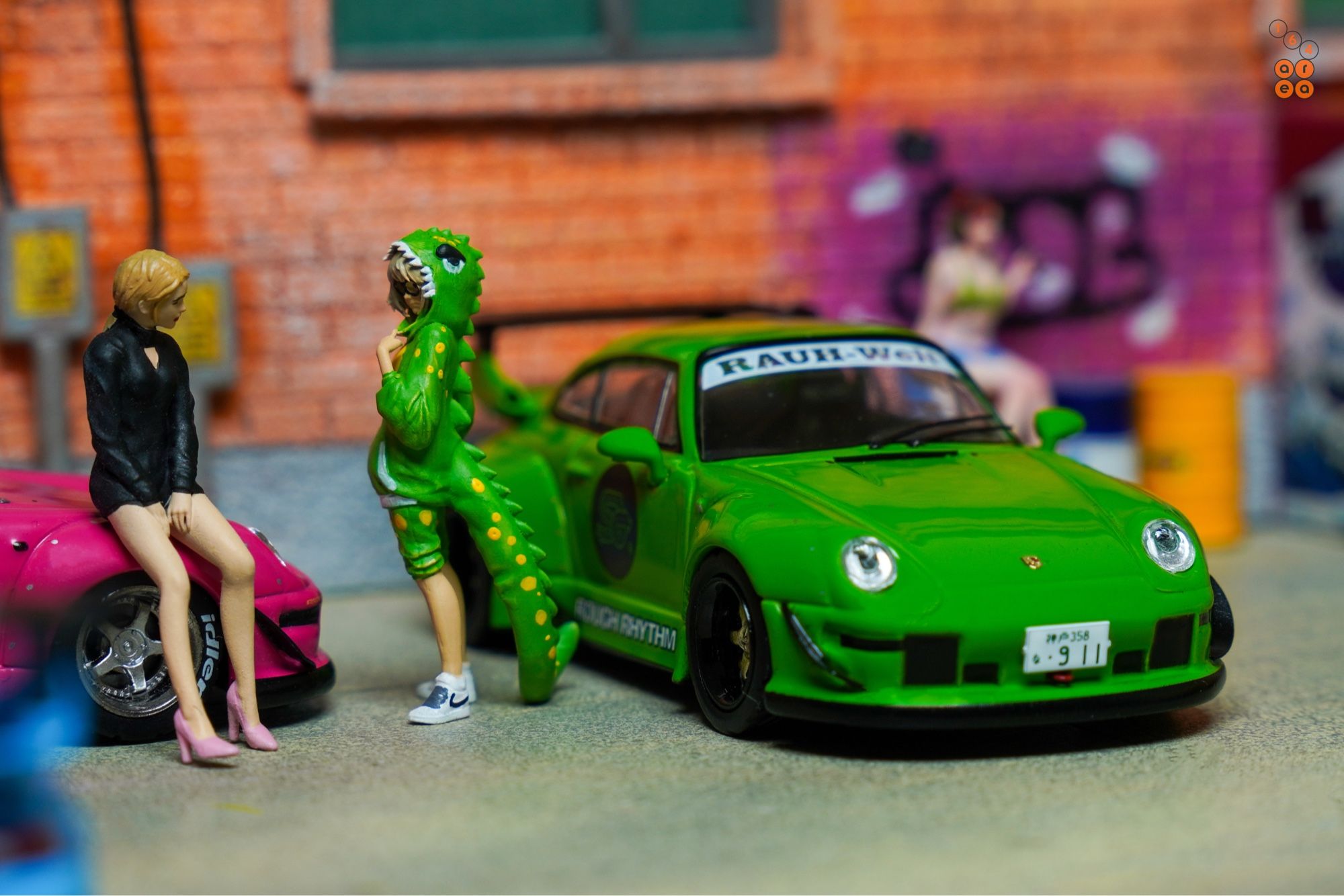 A female and a guy in cosplay suit beside Porsche RWB 993 Rough Rhythm by Tarmac Works in 1:64 scale with 1:64 figures on AREA 164