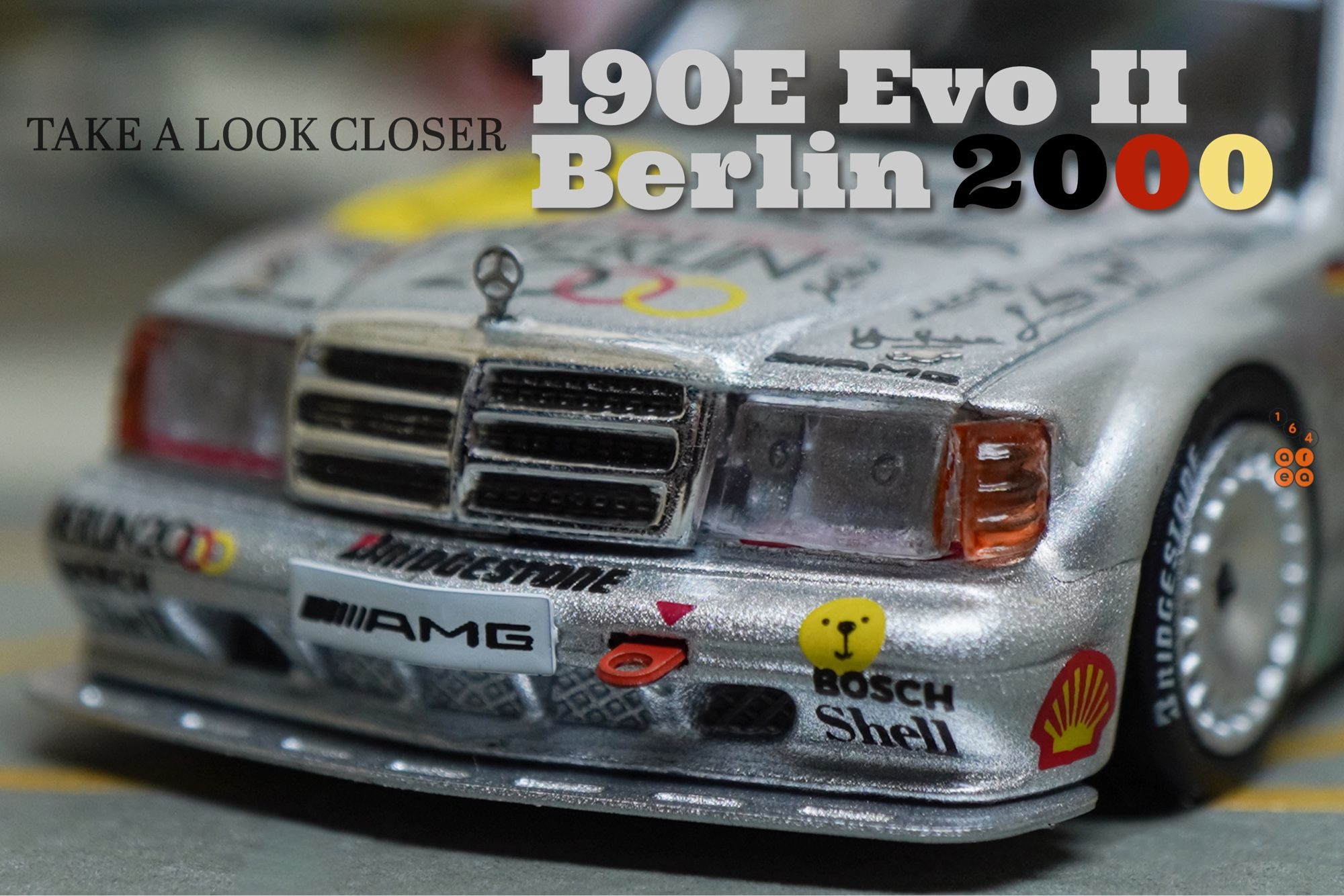 A close-up shot of Mercedes-Benz 190E 2.5-16 Evolution II, Berlin 2000 livery by Tarmac Works in 1:64 scale on AREA 164