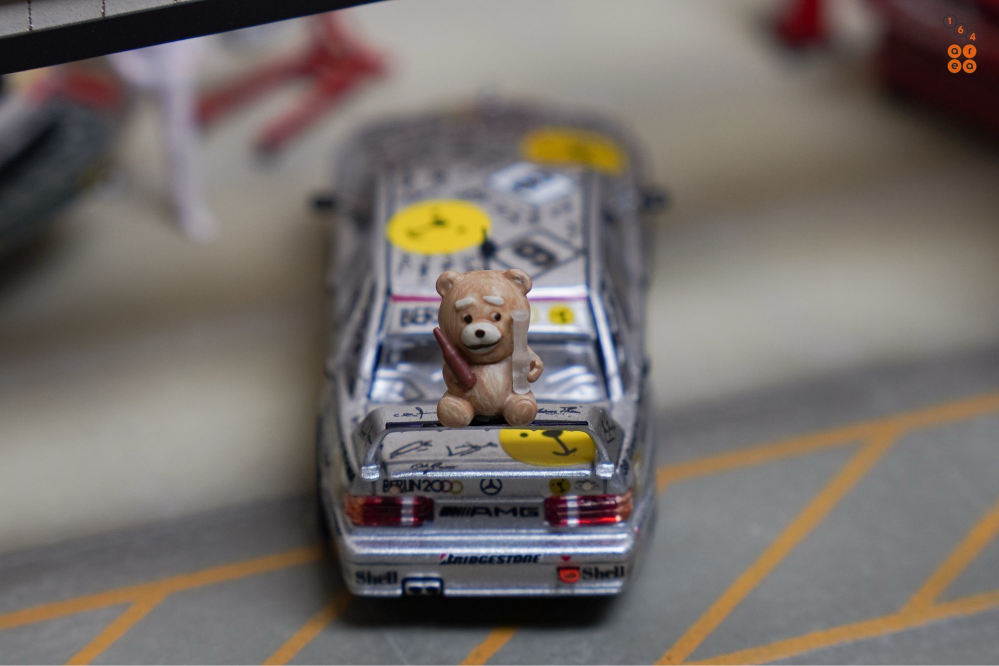 A Ted bear and on a rear wing of Mercedes-Benz 190E 2.5-16 Evolution II, Berlin 2000 livery by Tarmac Works in 1:64 scale with 1:64 figure on AREA 164