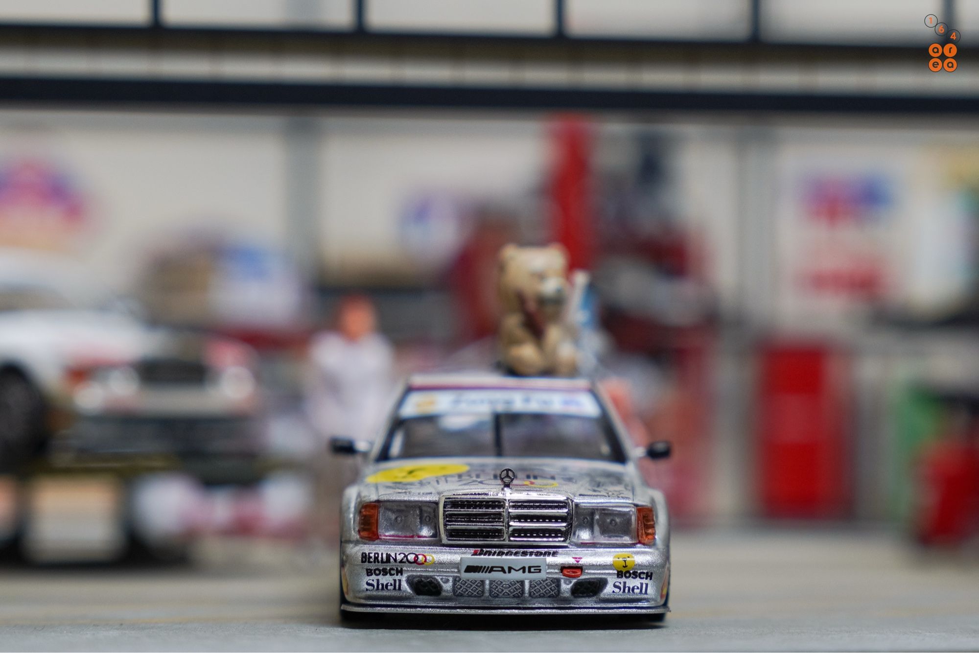 A front side of Mercedes-Benz 190E 2.5-16 Evolution II, Berlin 2000 livery by Tarmac Works in 1:64 scale with 1:64 figures on AREA 164