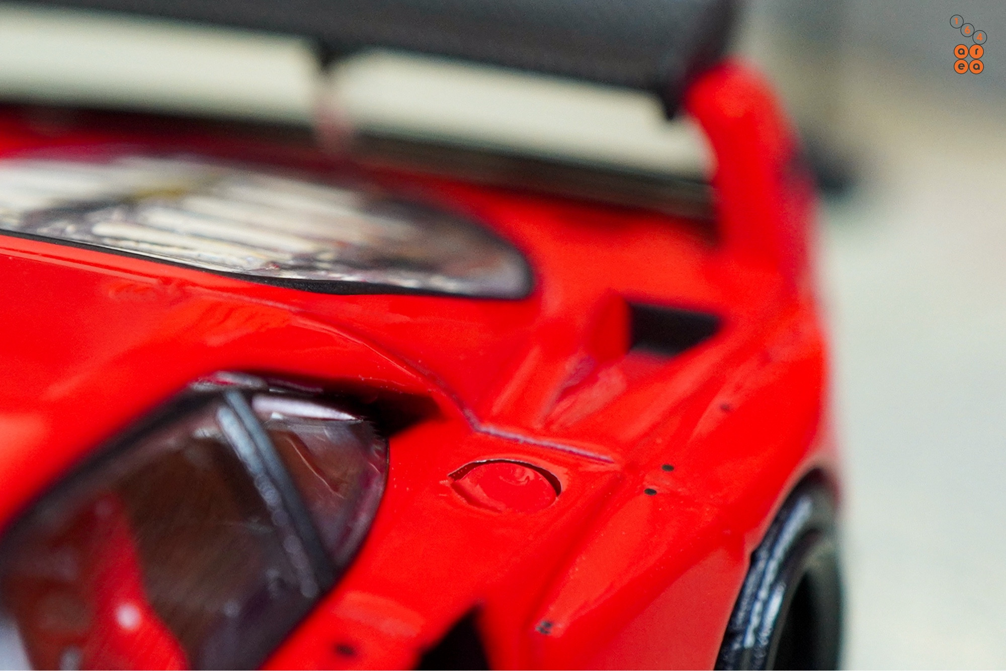 A close-up shot of a red LB-WORKS Ferrari F40 by INNO64 in 1:64 scale on AREA 164