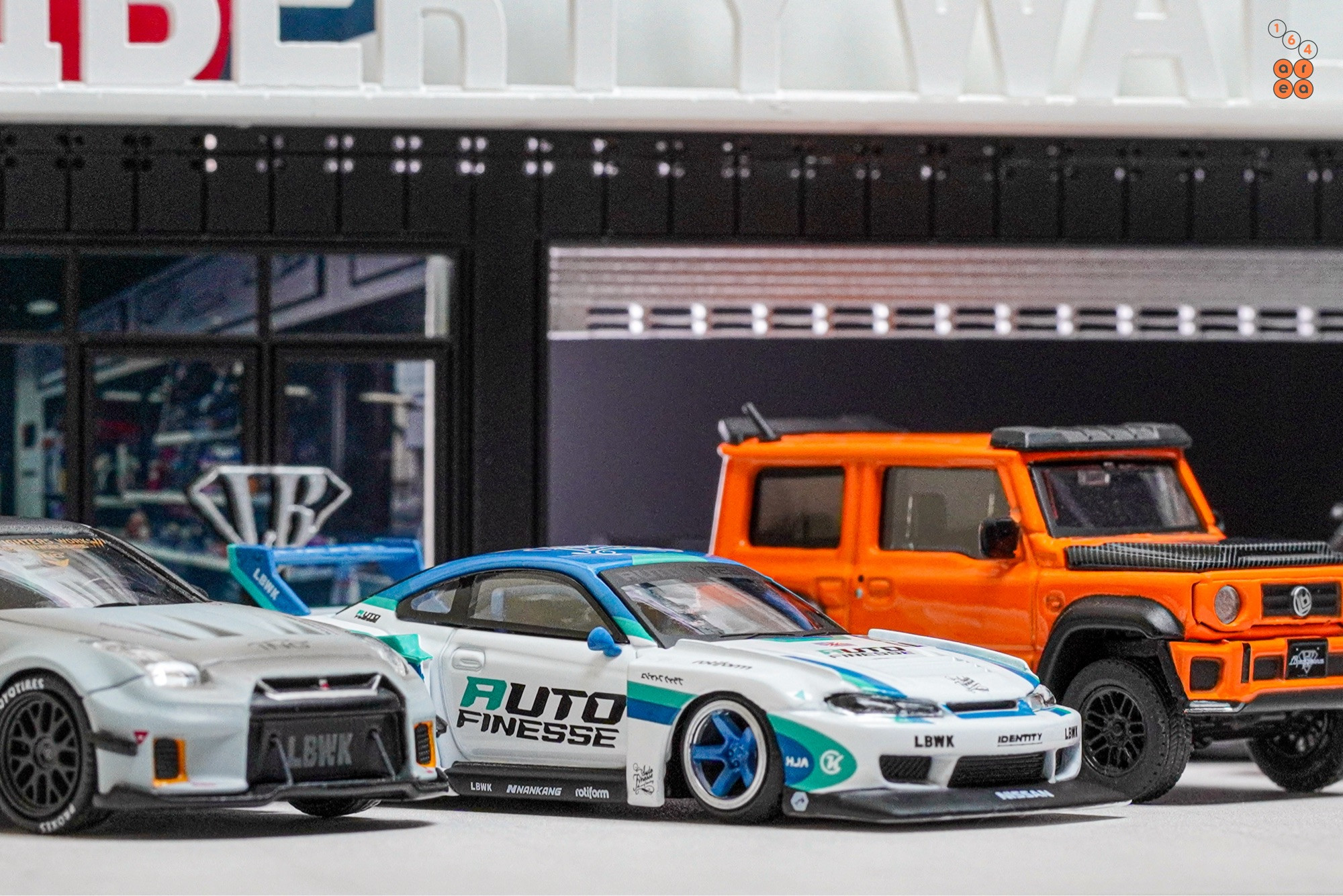 3 LBWK cars including Nissan Skyline R35 Zero Fighter, Silvia S15 Auto Finesse and Suzuki Jimny in 1:64 scale on AREA 164