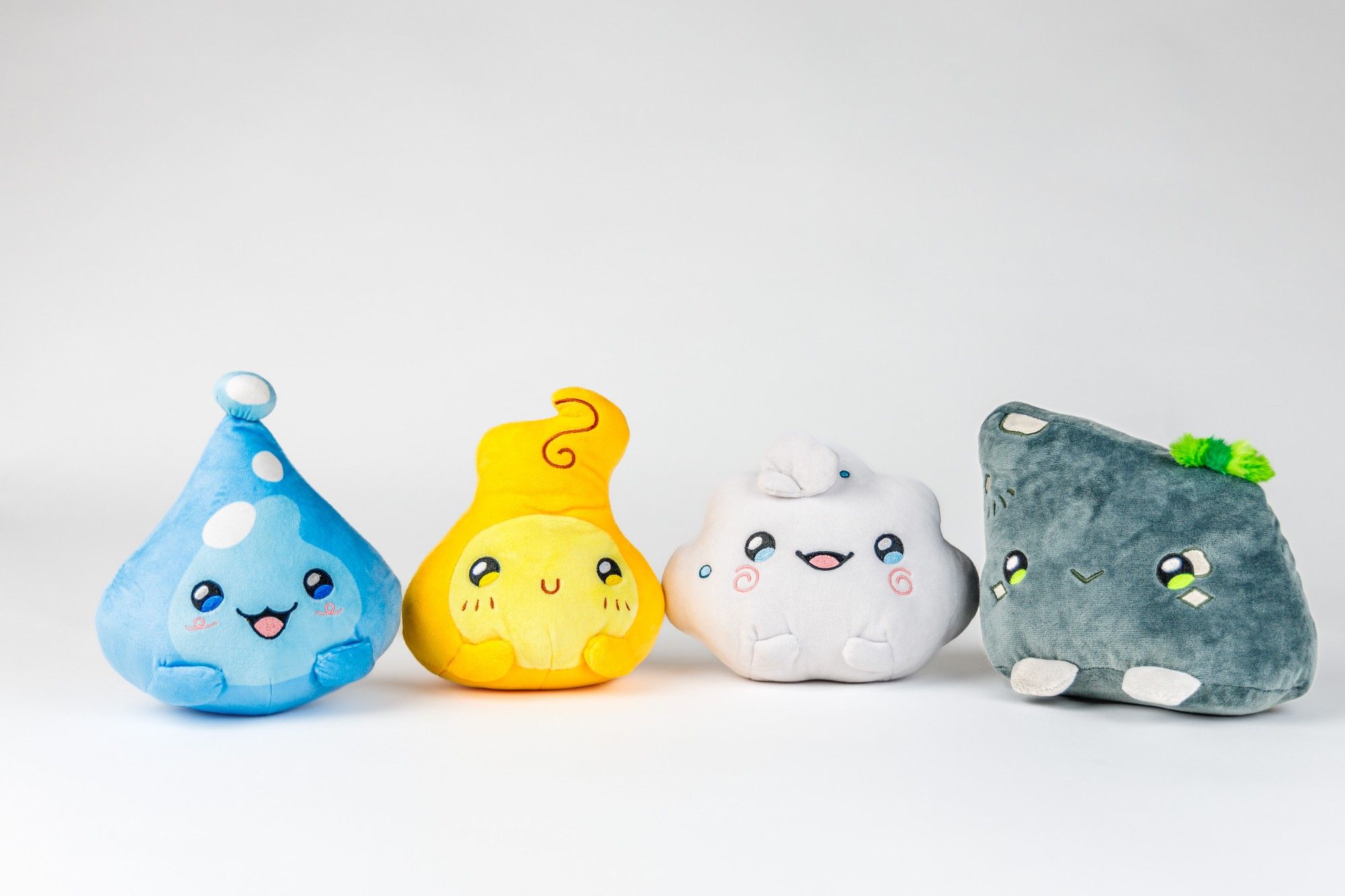 A group picture of 4 elemental blob plushies. from left to right is water, fire, air, earth.