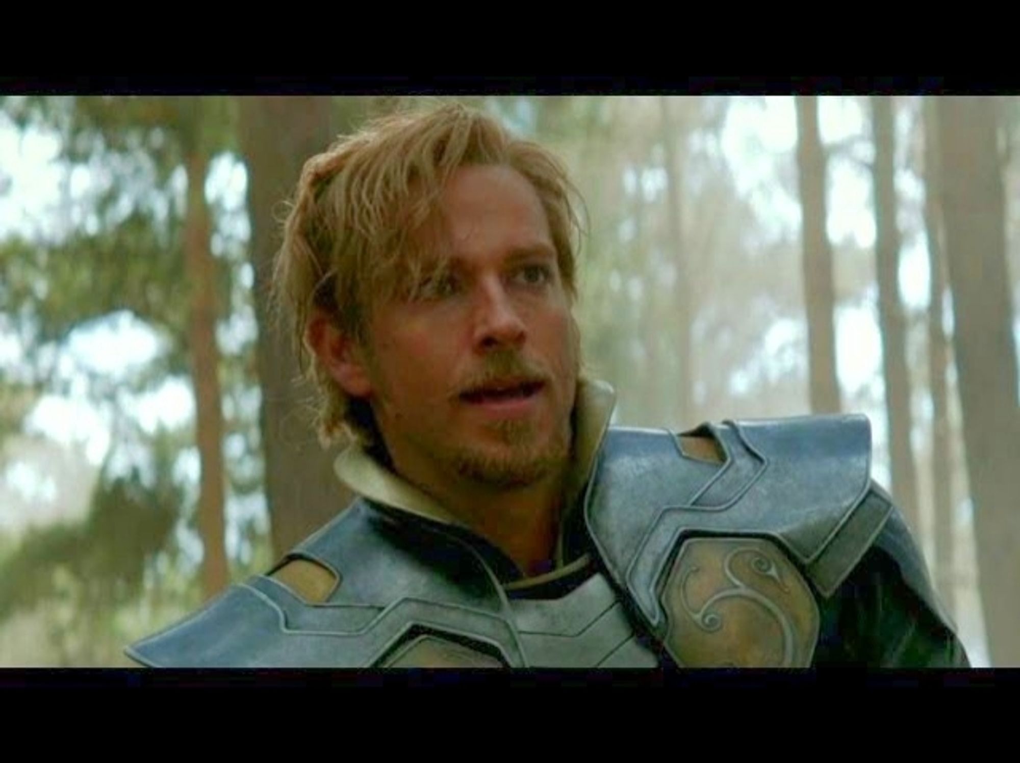 zachary levi as fandral in thor the dark world, also with a blonde beard and green asgardian armor, but with more of a bleached blonde beach bum vibe than a well coiffed robin hood.