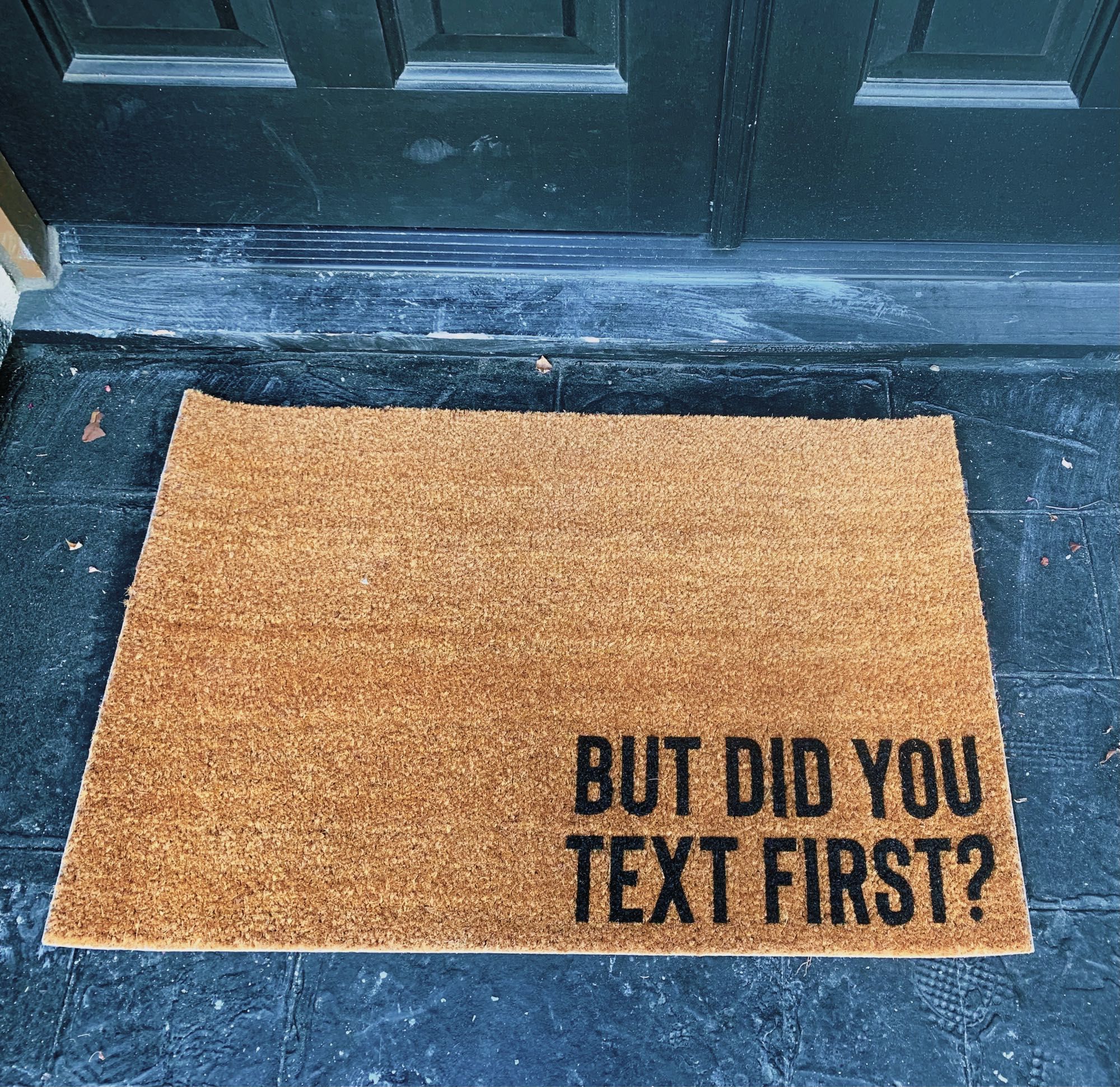 Old doormat that read “BUT DID YOU TEXT FIRST?”