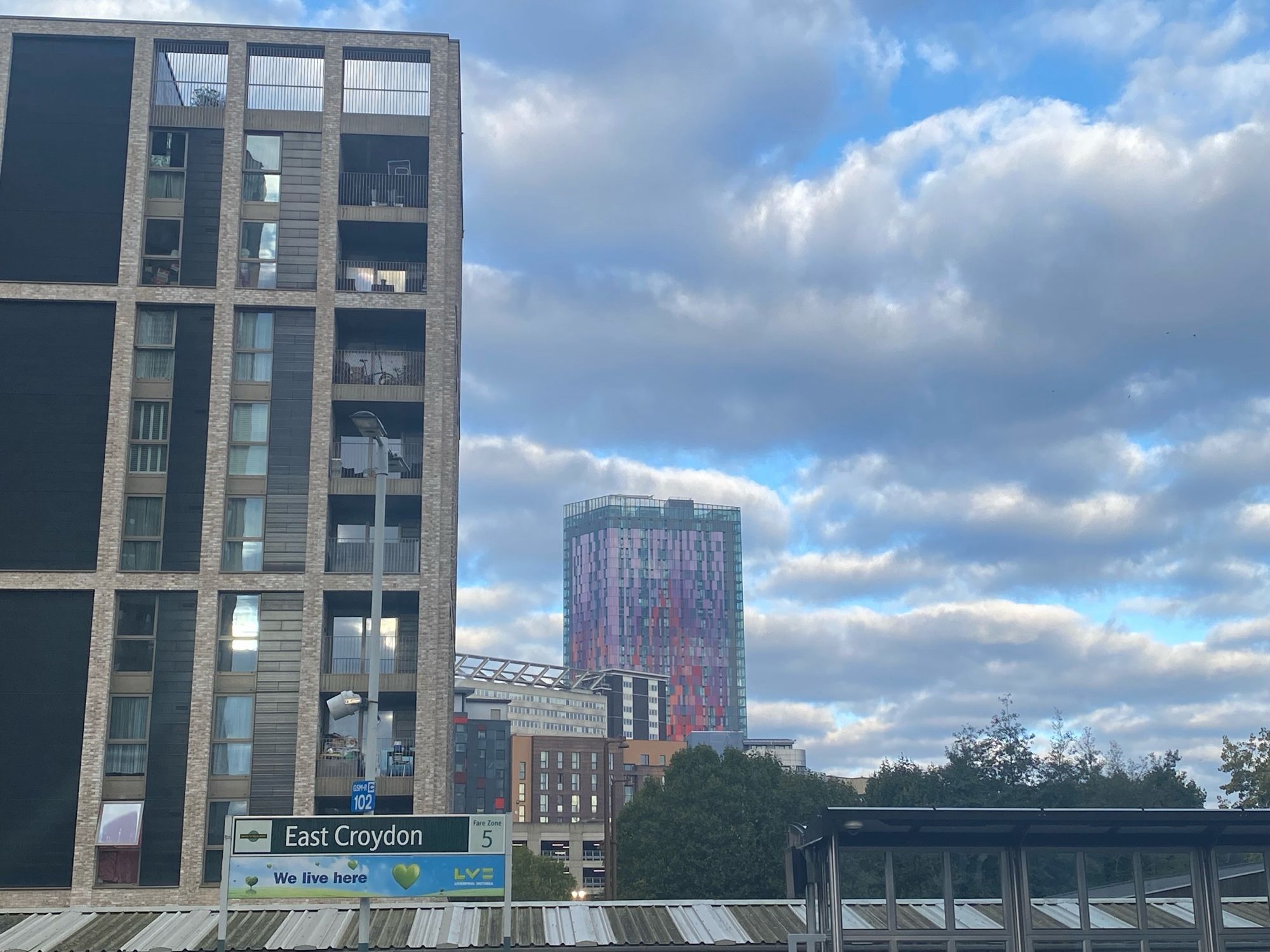 Contemporary architecture office blocks one is pink and purple tiled. Sky either longish clouds, violet and blue.