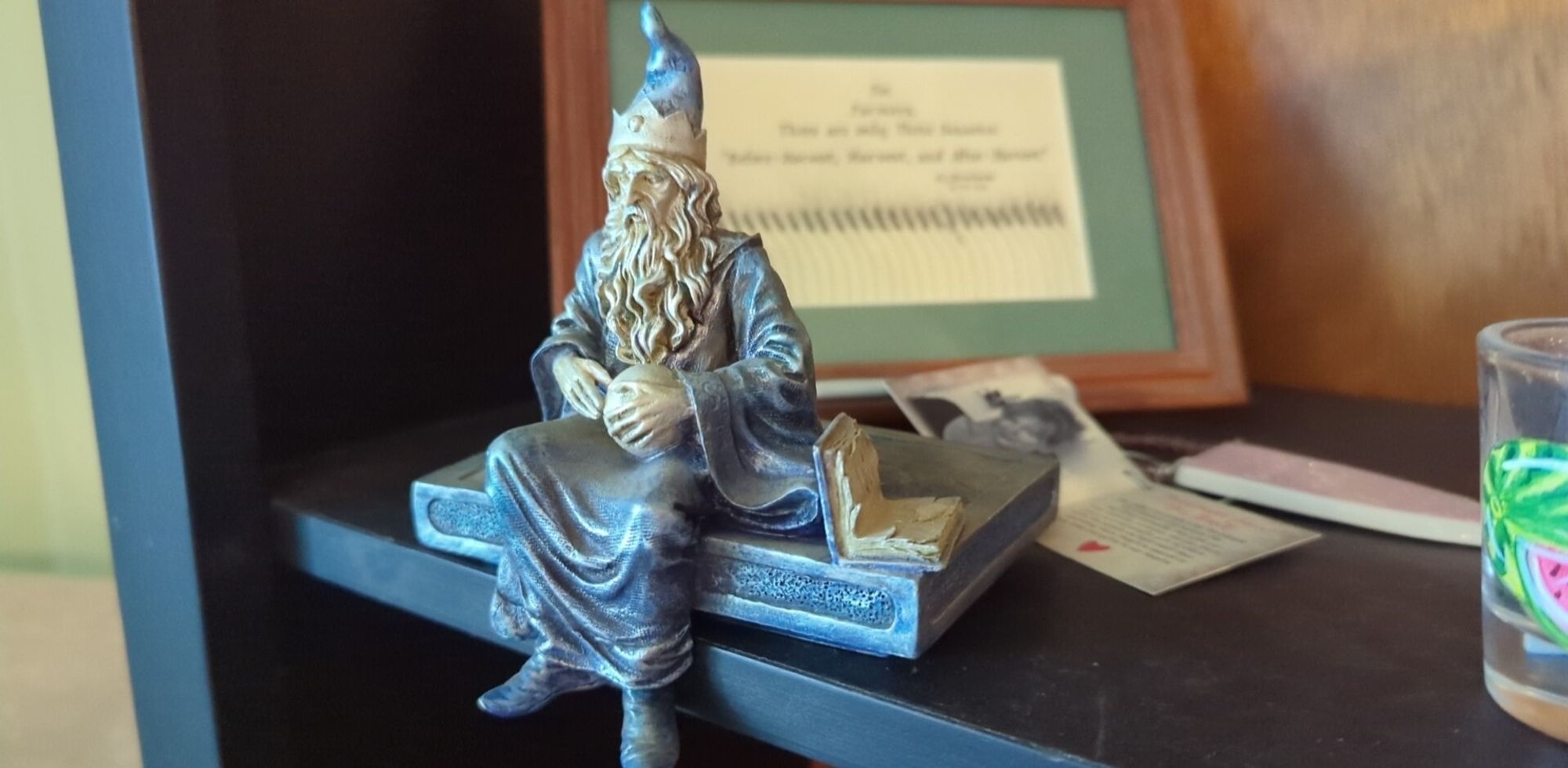 A final small wizard statue, they look contemplative while sitting on a book while they read a smaller book