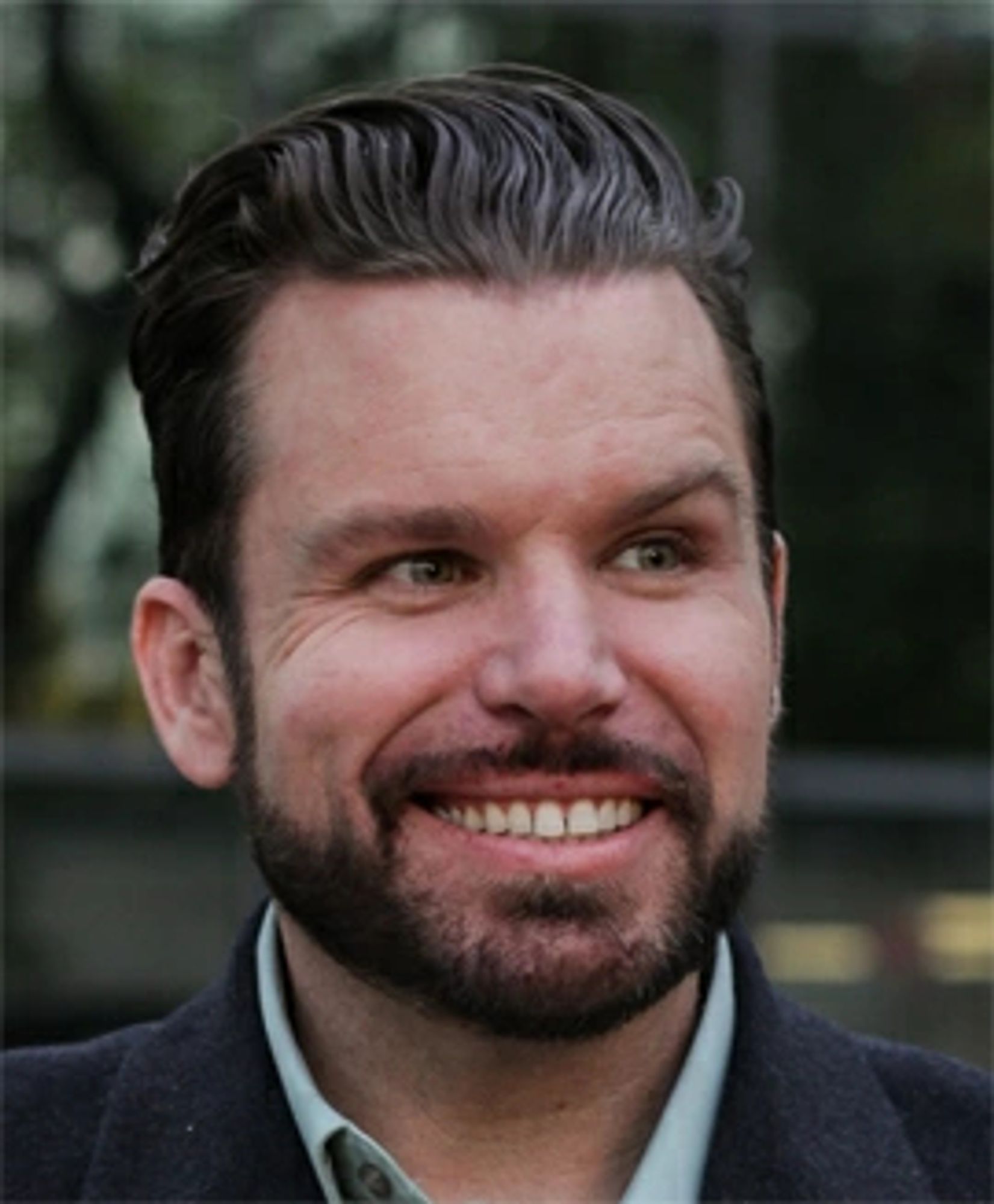 Justin Harrison, a white man with medium-length dark brown hair, a full, closely cropped beard, and a crazy look on his face.