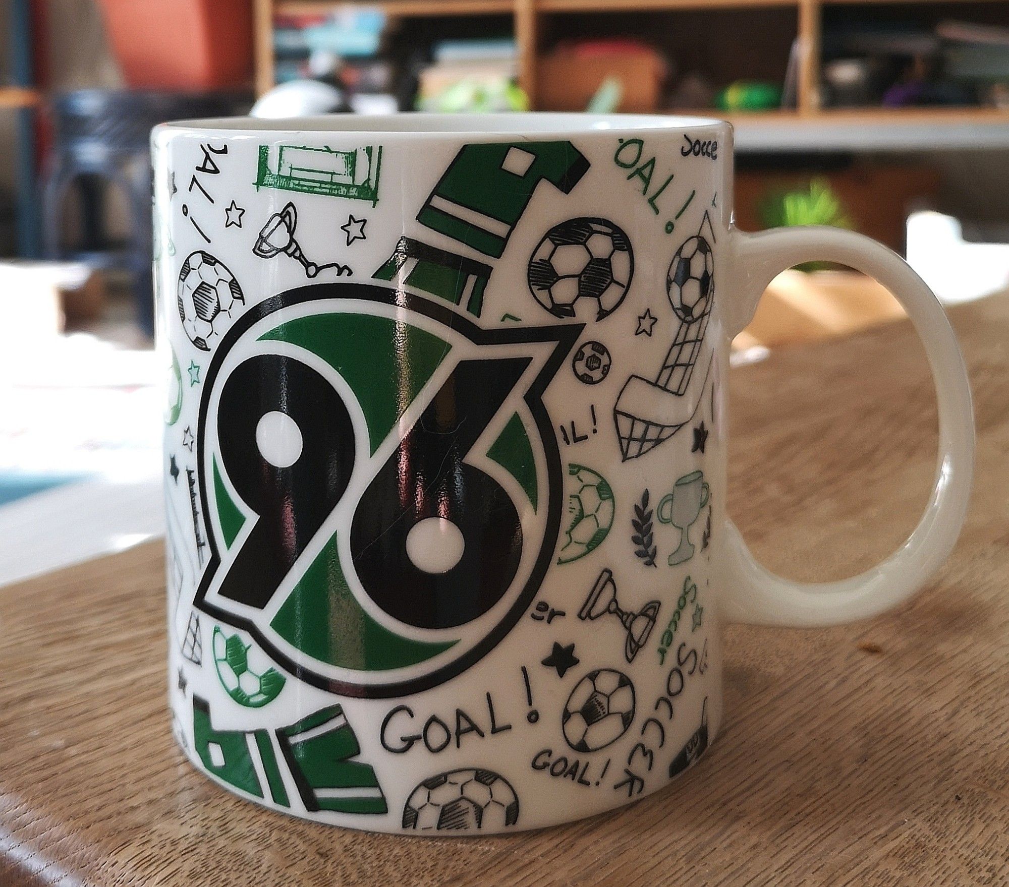 Große weiße Kaffeetasse mit Hannover 96 Logo und vielen weiteren Fußballmotiven (Fußball, Pokal, Trikot, Tornetz, Stern....)