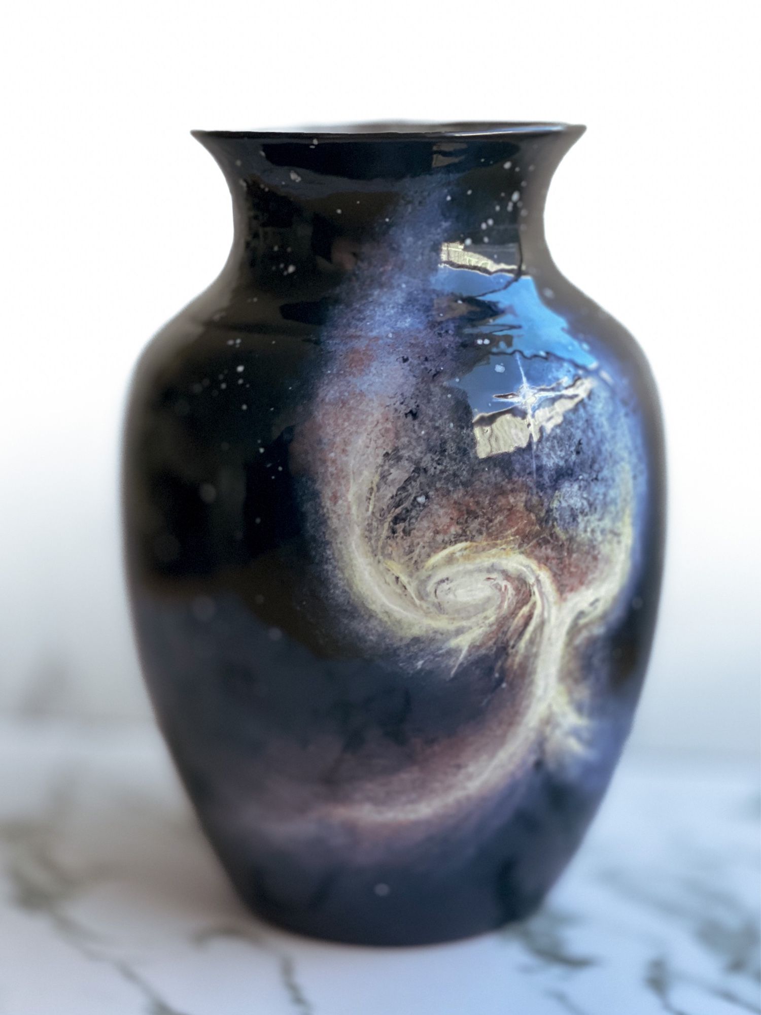 Vase featuring two merging galaxies that unite in a vertical formation resembling a tree or “Angel wing” and one bright star in center. (Left)