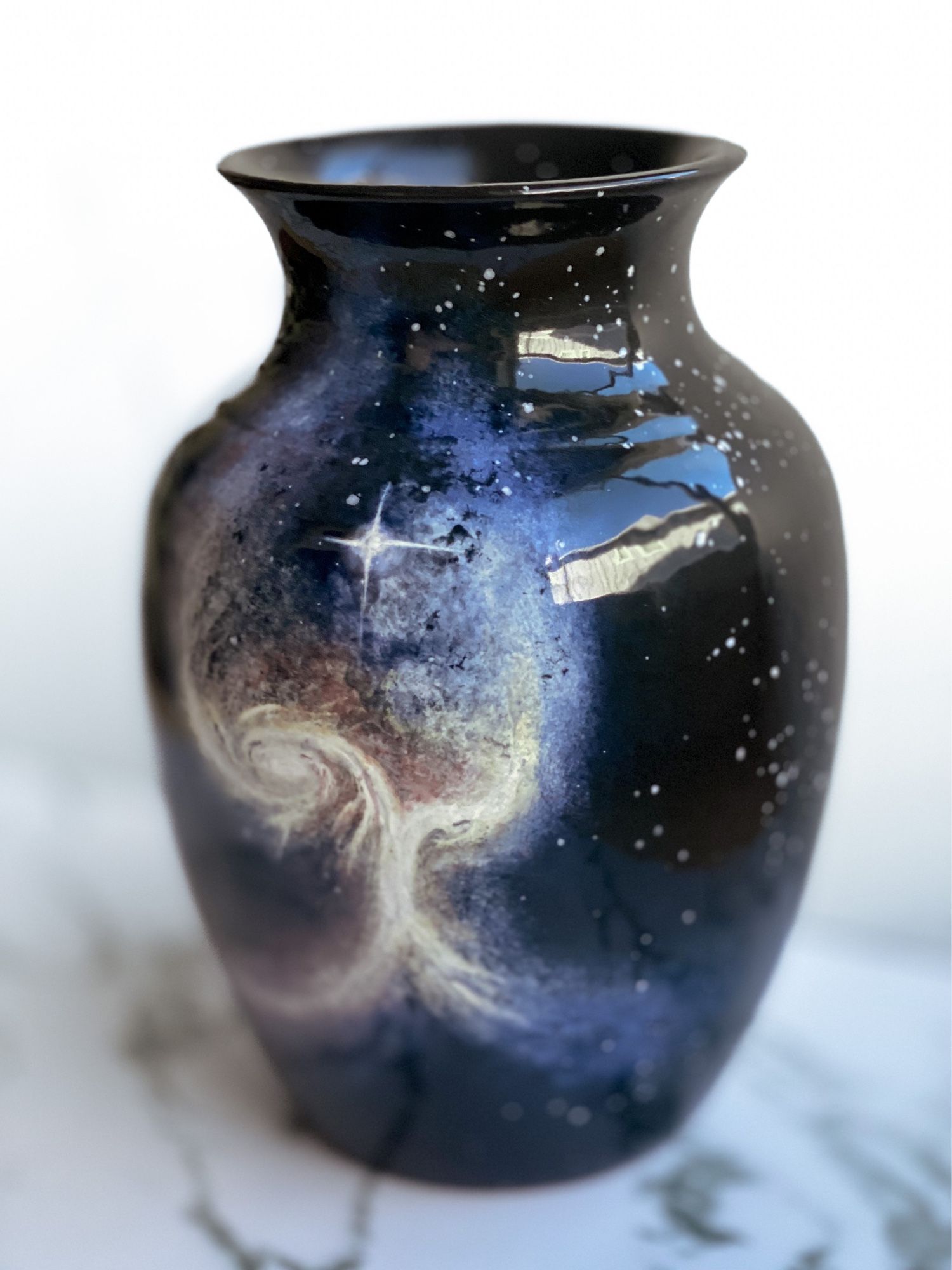 Vase featuring two merging galaxies that unite in a vertical formation resembling a tree or “Angel wing” and one bright star in center. (Right)