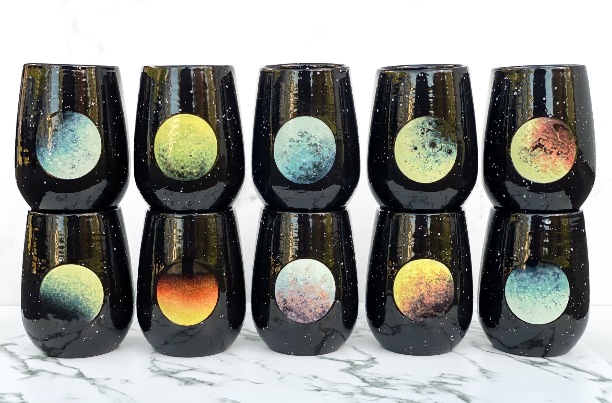 Ten cups featuring colorful imagined planets surrounded by stars.