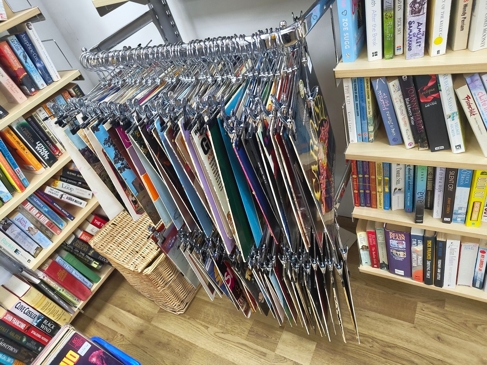 Charity shop records displayed using those coat hangers with the two clips for hanging skirts.