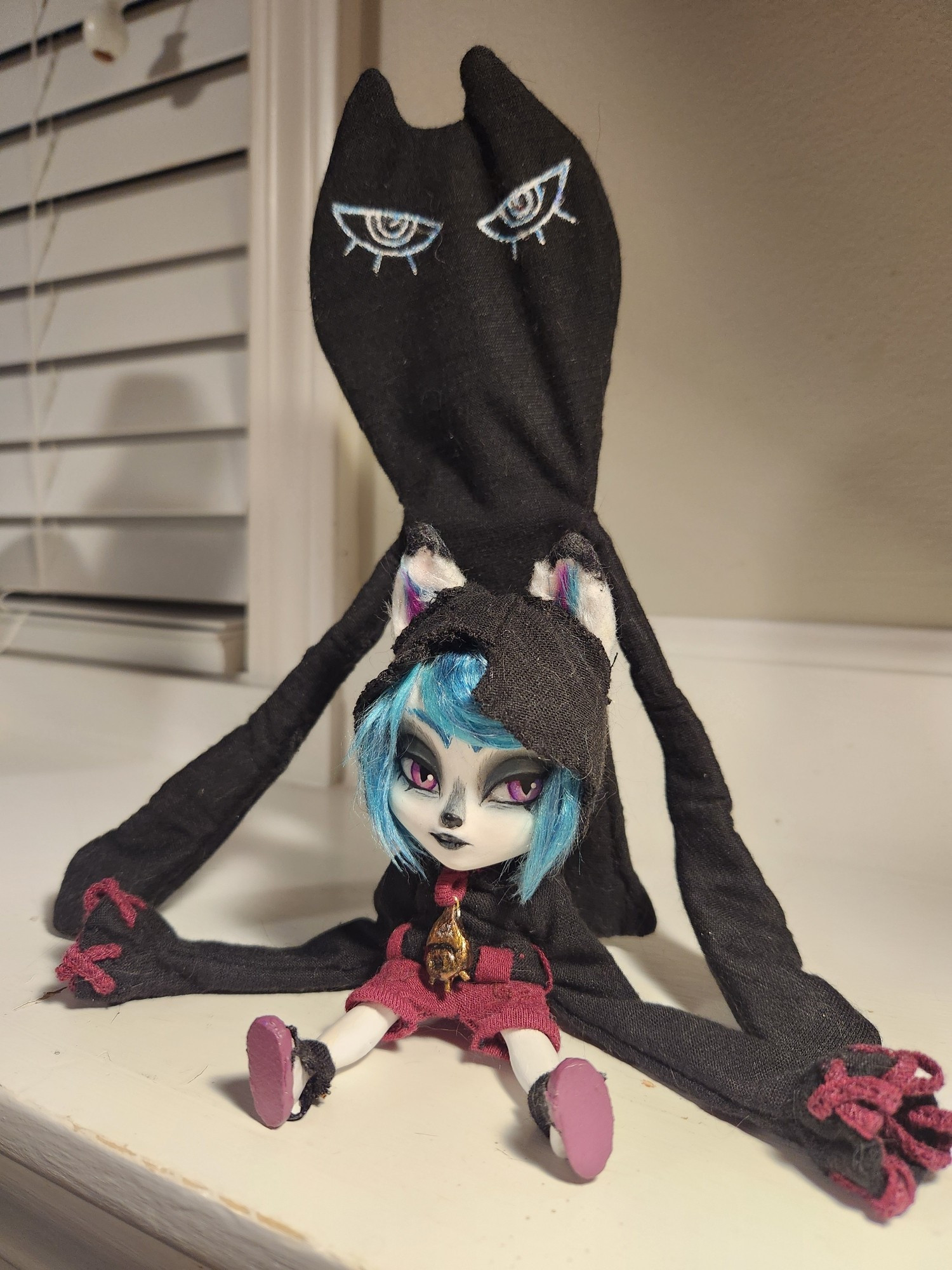 A doll of the character Vex from League of Legends. She's sitting with the ends of her sleeves connecting to Shadow who stands behind her.