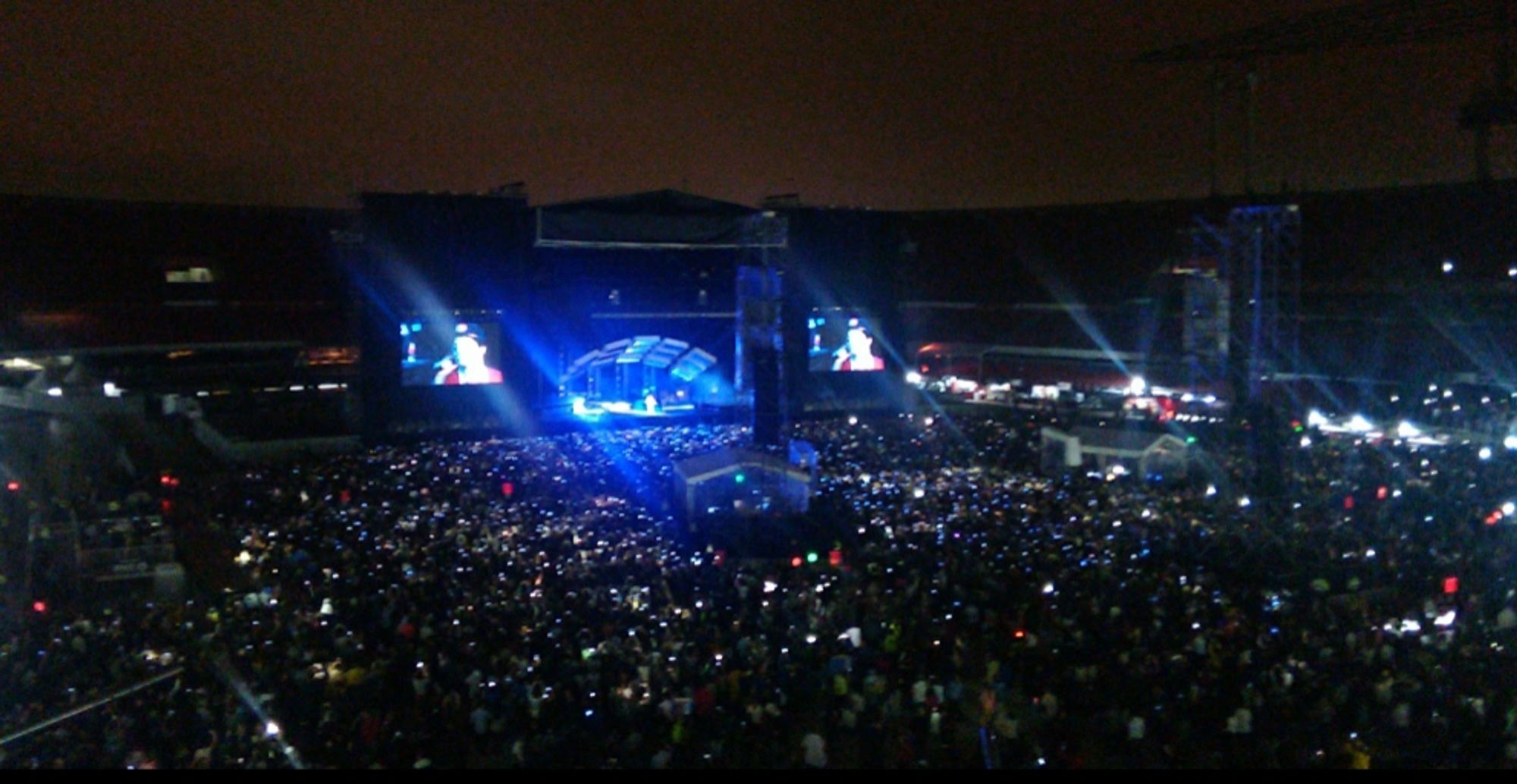 Duas telas grandes transmitindo o show do Bruno Mars no estádio Morumbi em 2017
Pista e arquibancadas com muitas pessoas