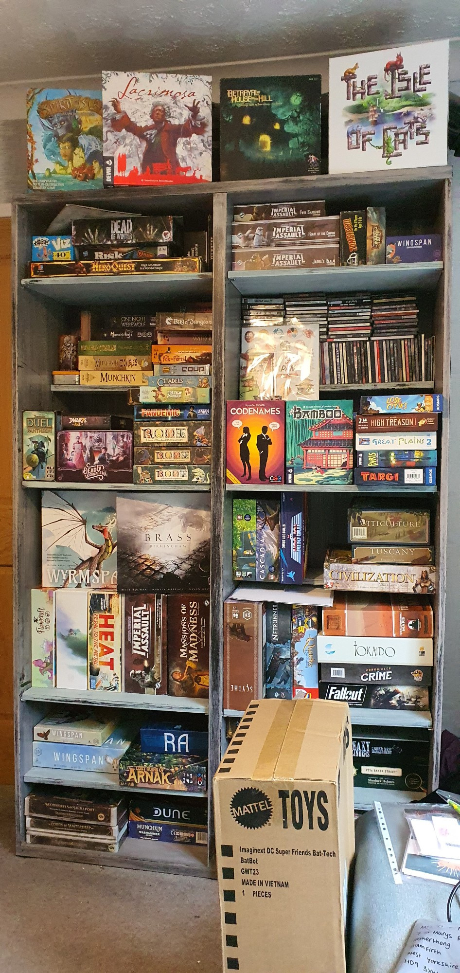 A bookcase with lots of boardgames stored. They're somewhat neat. 