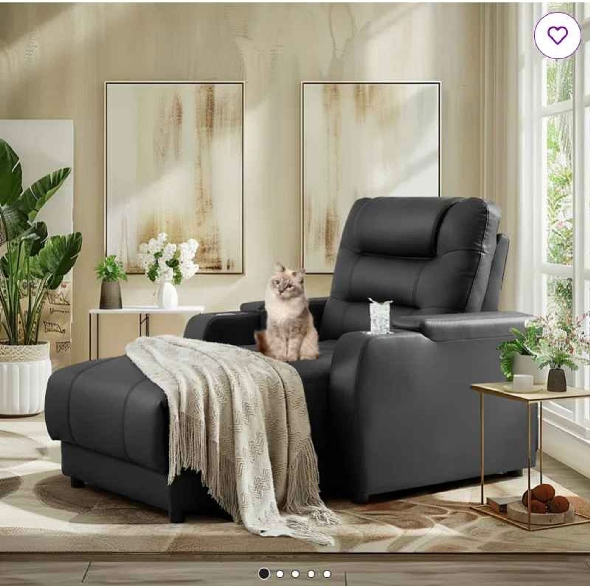 A fluffy cat on a black leather chaise lounge, sitting upright and looking curious