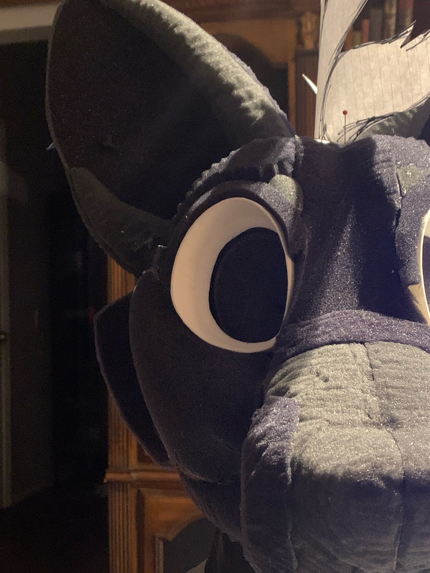 A charcoal foam carved fursuit head base. The picture was taken close to the head so it’s hard to make out what species this might be. Pointy ears and cheek fluff are in frame.