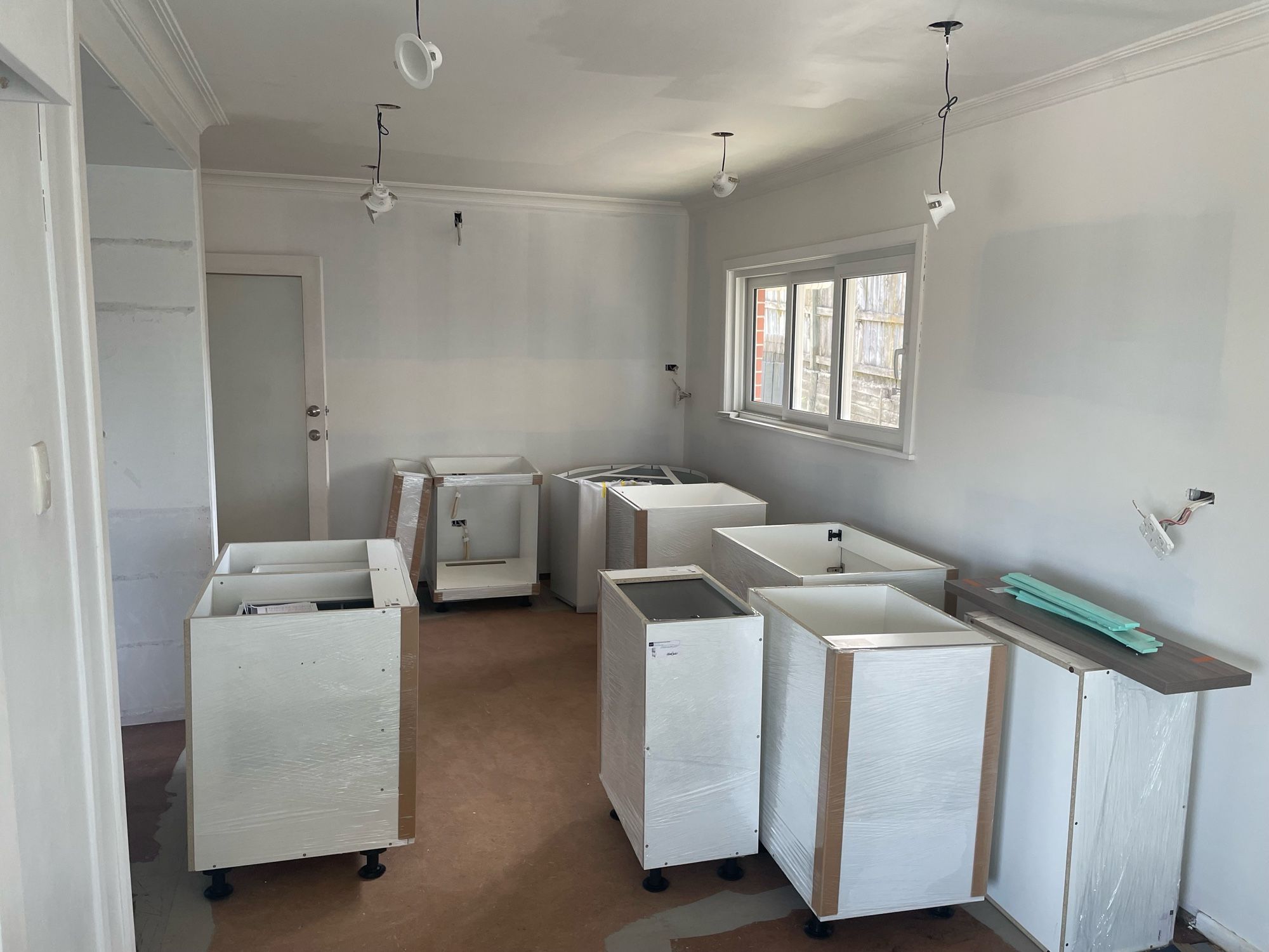 Kitchen cabinets in disarray waiting to be installed.