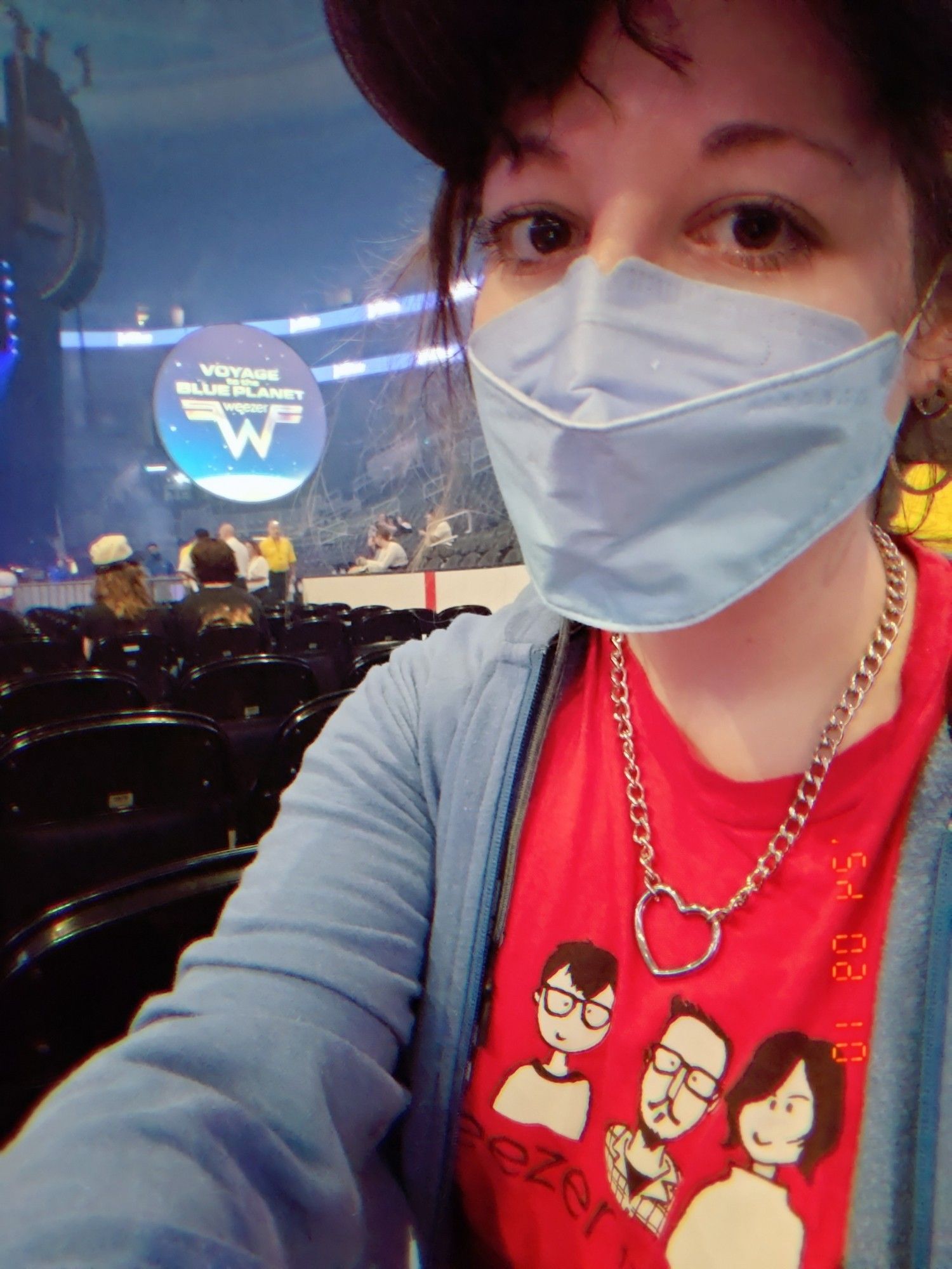 Lady in a Weezer fan club t-shirt and k95 mask at a Weezer "journey to the blue planet" stadium tour concert.