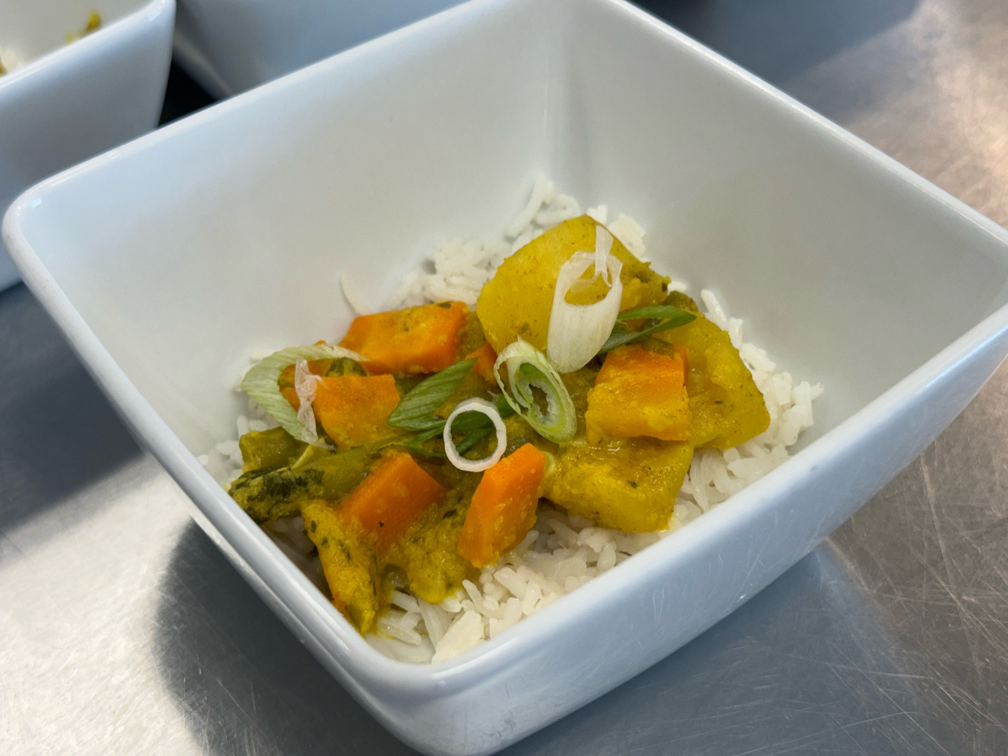 Vegetable curry with potatoes, green onion, carrots, garlic, green beans mixed with onion-ginger paste and rendered coconut milk