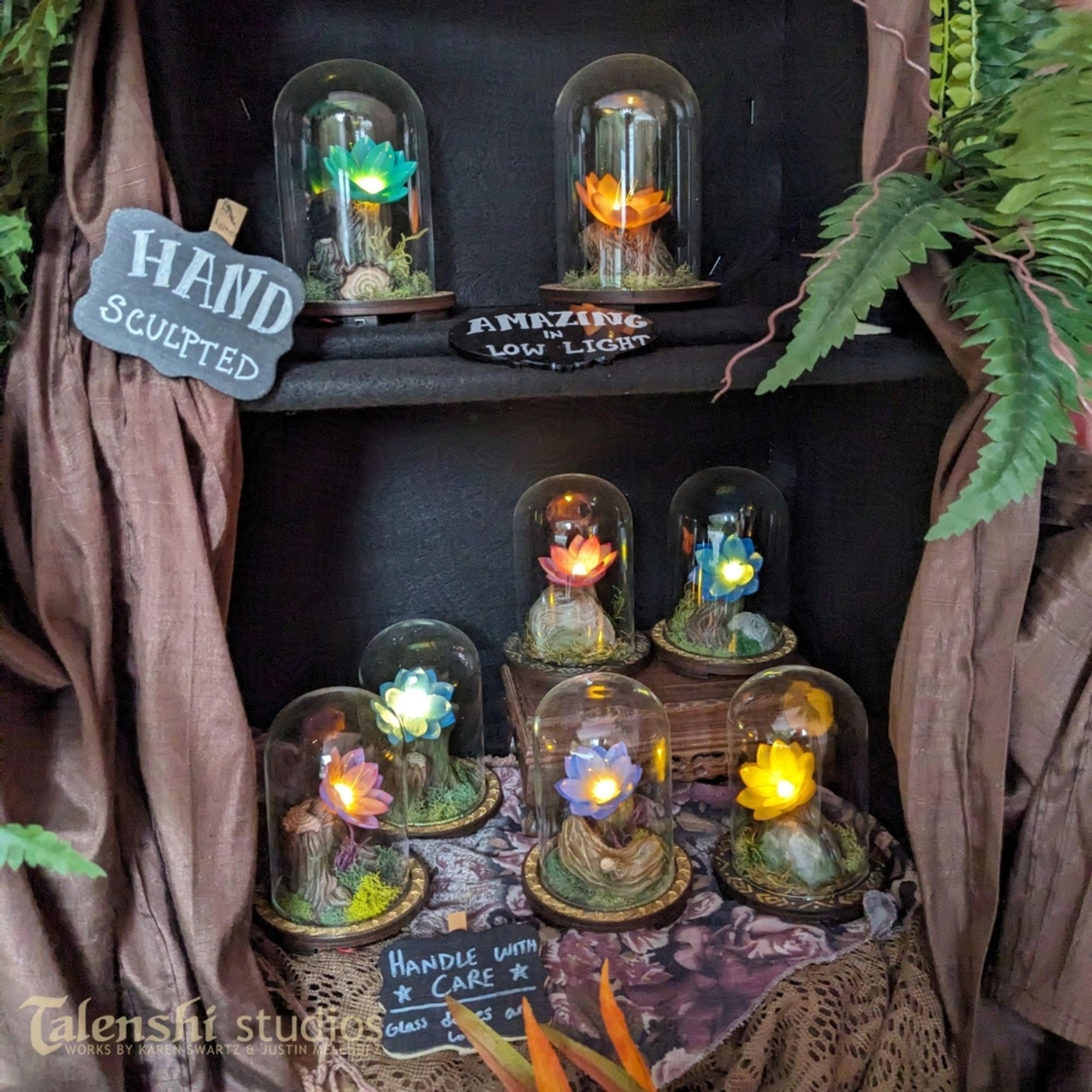 Our display of one of a kind enchanted flower dioramas with glass domes. The flowers are resin printed from an original model by my partner, and I sculpted the rest from sculpey air dry porcelain clay.