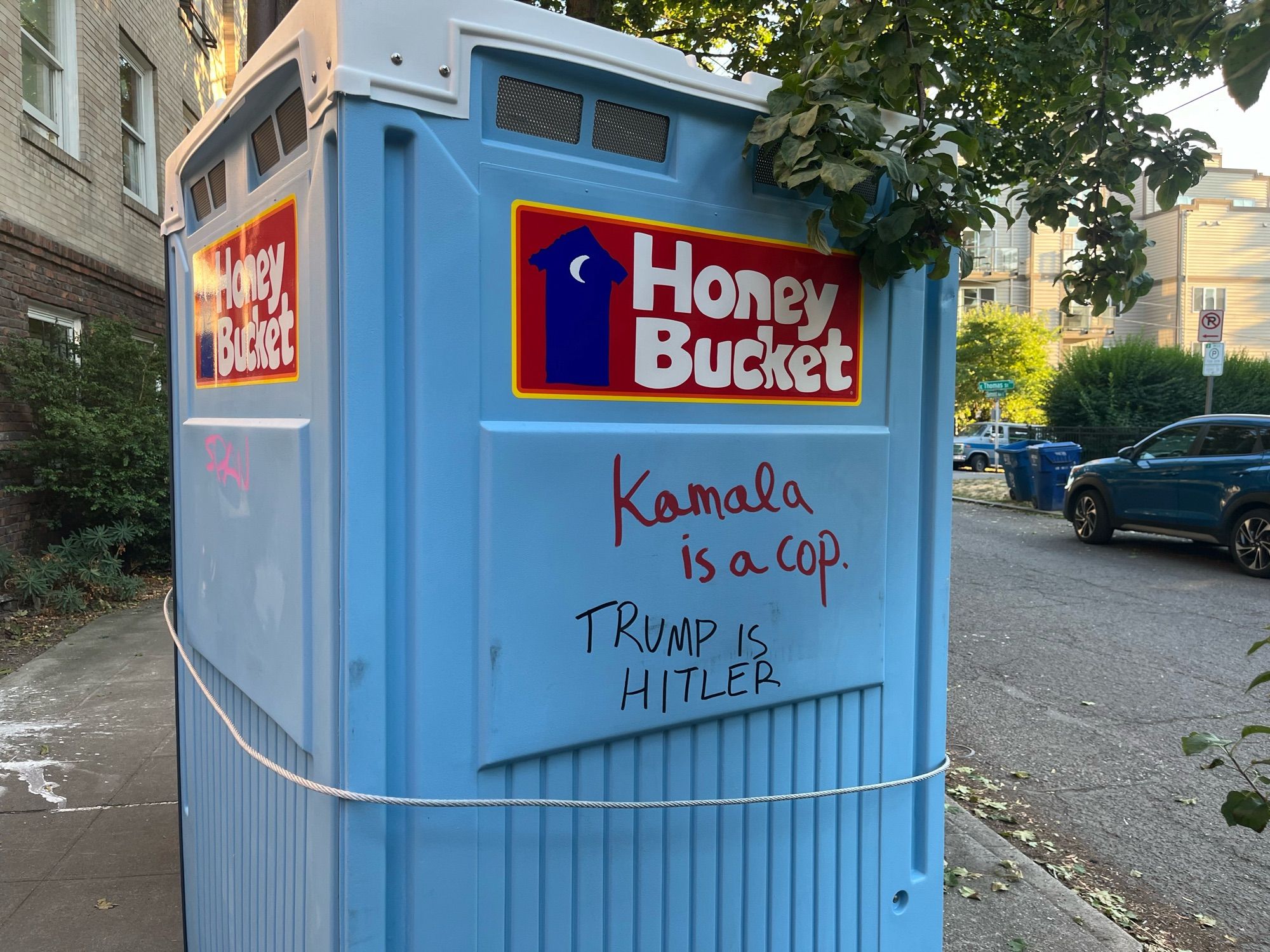 graffiti on a honey bucket portable toilet

red: kamala is a cop
black: TRUMP IS HITLER