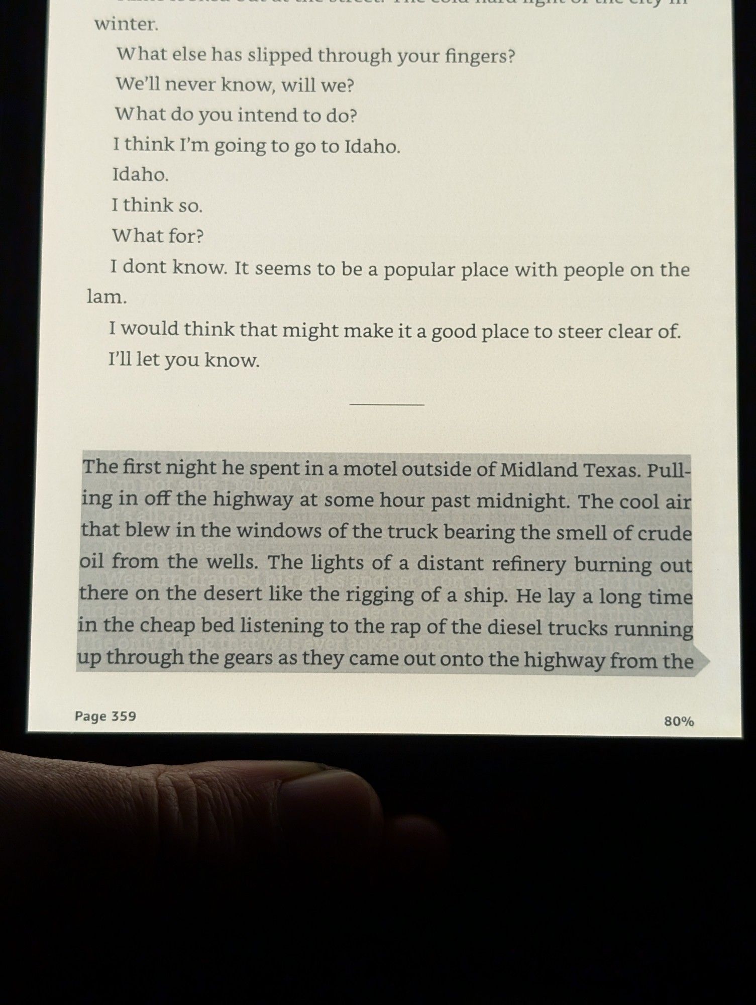 cormac mccarthy's the passenger (2002):

"The first night he spent in a motel outside of Midland Texas. Pull ing in off the highway at some hour past midnight. The cool air that blew in the windows of the truck bearing the smell of crude oil from the wells. The lights of a distant refinery burning outa there on the desert like the rigging of a ship. He lay a long time in the cheap bed listening to the rap of the diesel trucks running up through the gears as they came out onto the highway from the..."