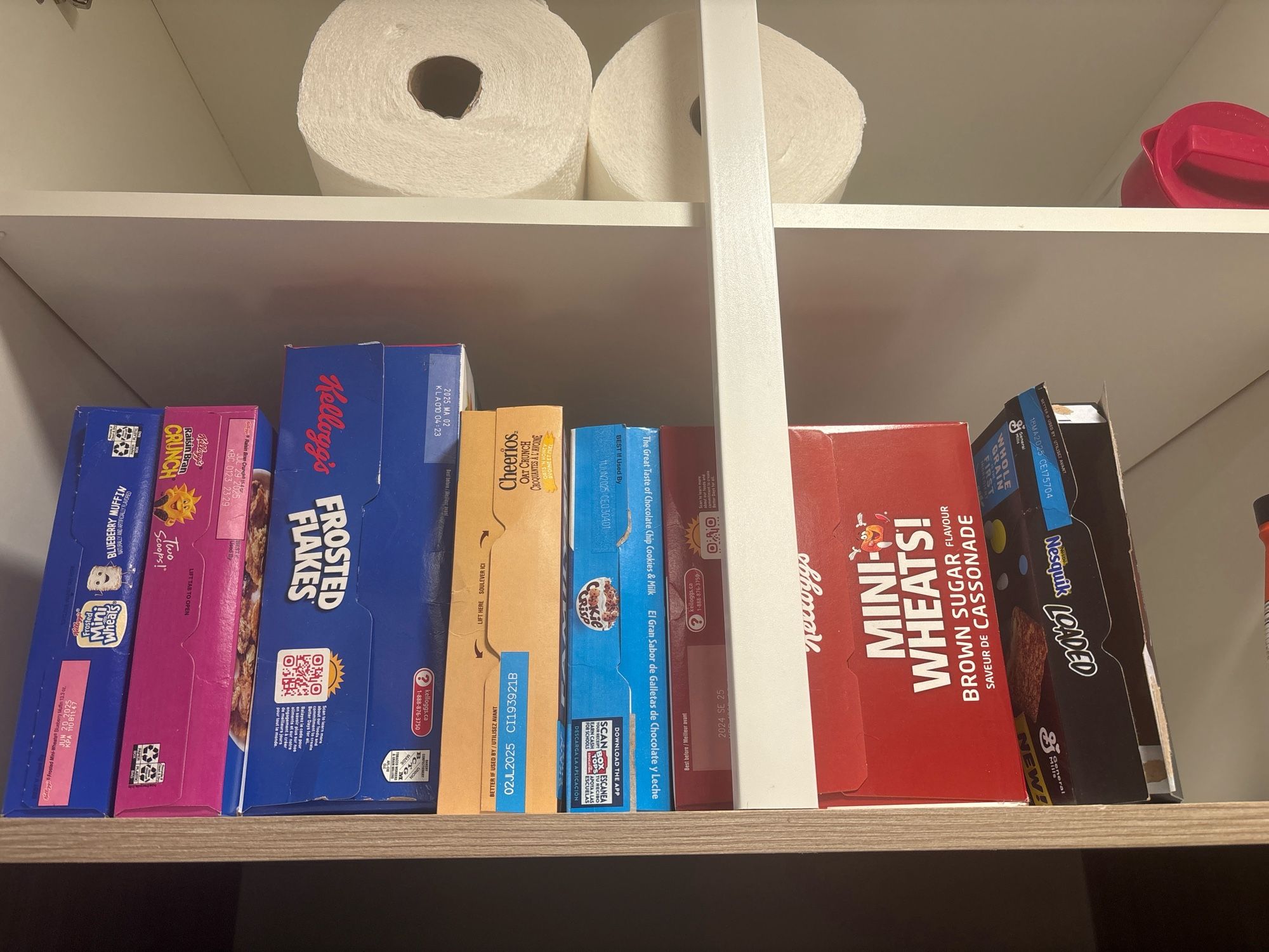 A shelf of cereals with a mix of “adult” and “kid” stuff.