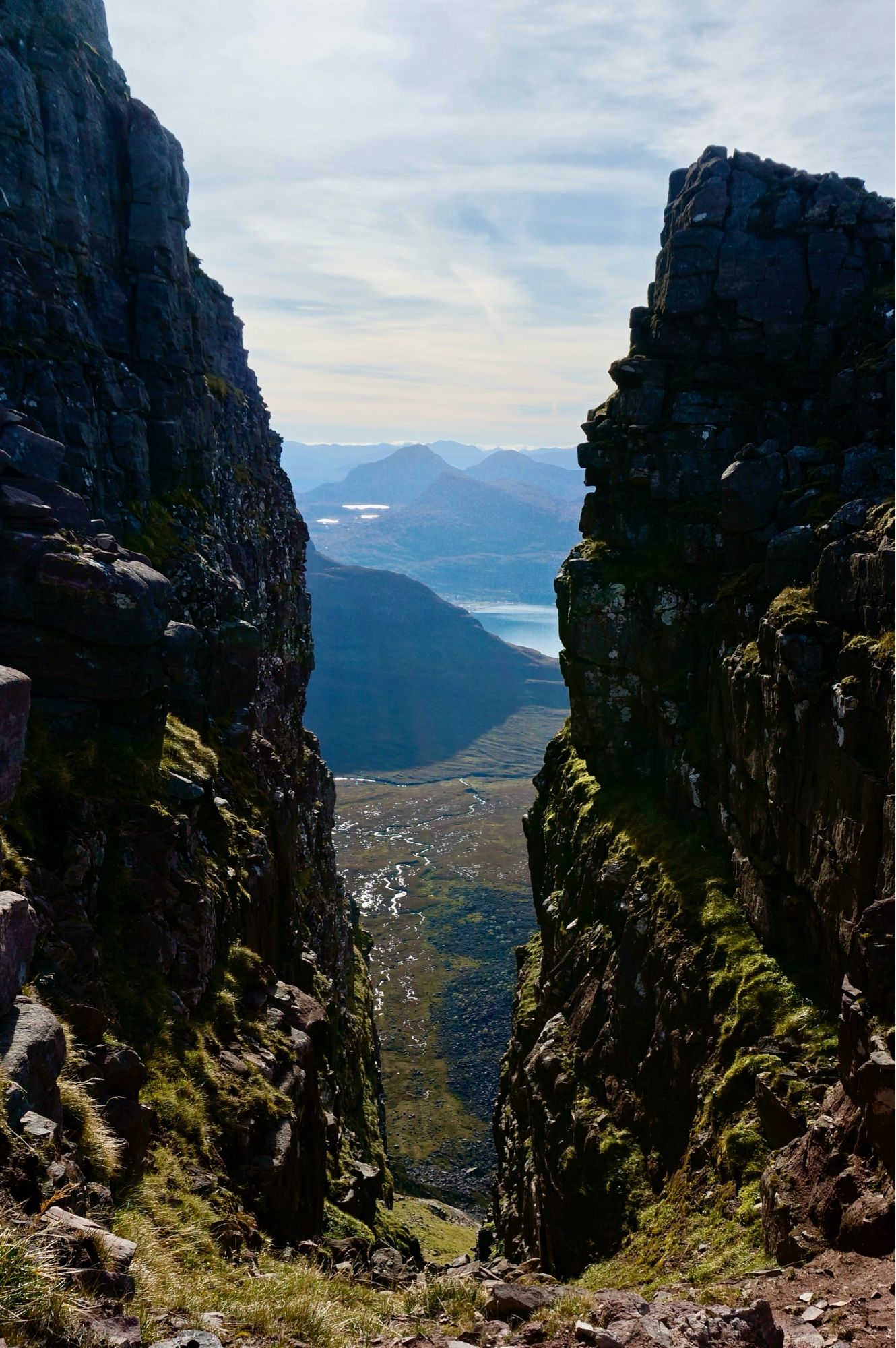 Looking down a huge gash of a gully framing far hills