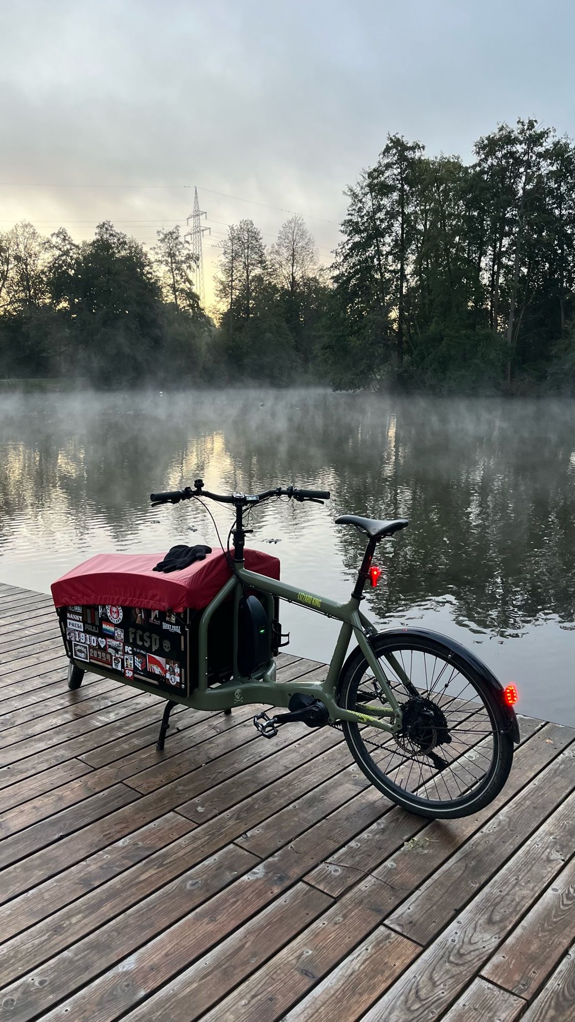 Bullitt am Aueweiher. Nebel steigt vom Wasser auf. Der Himmel kündigt einen sonnigen Morgen an.