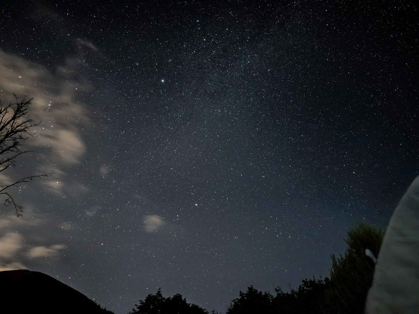 Starry night skies viewed from where I was sitting outside my tent after dark, with the edge of the tent just peeping in on the right.