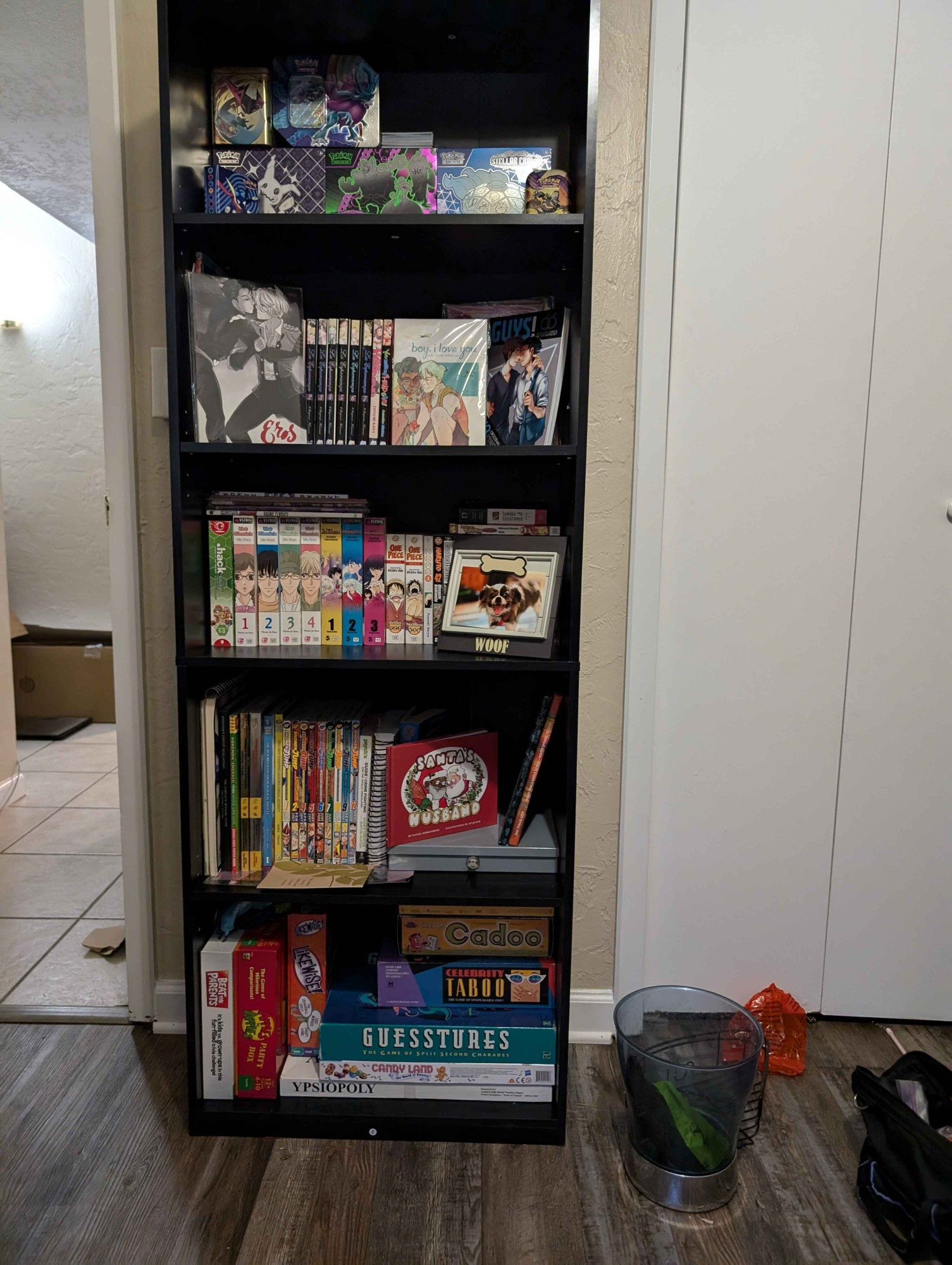 a bookshelf of my collection of manga, comics, pokemon cards, and board games