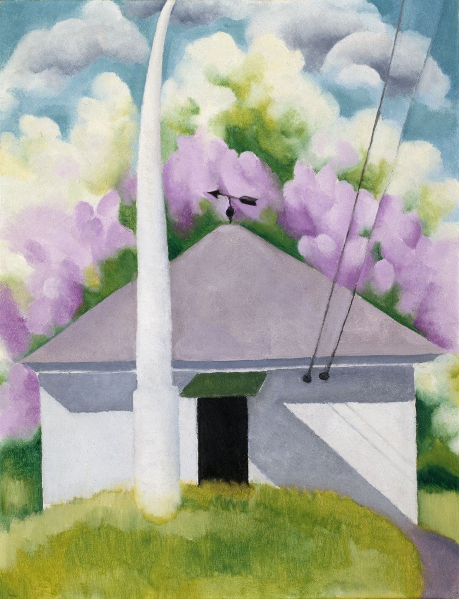 In this work, Georgia O’Keeffe painted the small building that housed the darkroom of her husband, Alfred Stieglitz, in Lake George, New York. The couple often took on the same subjects, and Stieglitz photographed this building the same year on a snowy day. O'Keeffe selected a springtime view, employing lush pastel colors for the flowering trees and simplifying the architecture to omit the house’s chimney, window, and horizontal siding.