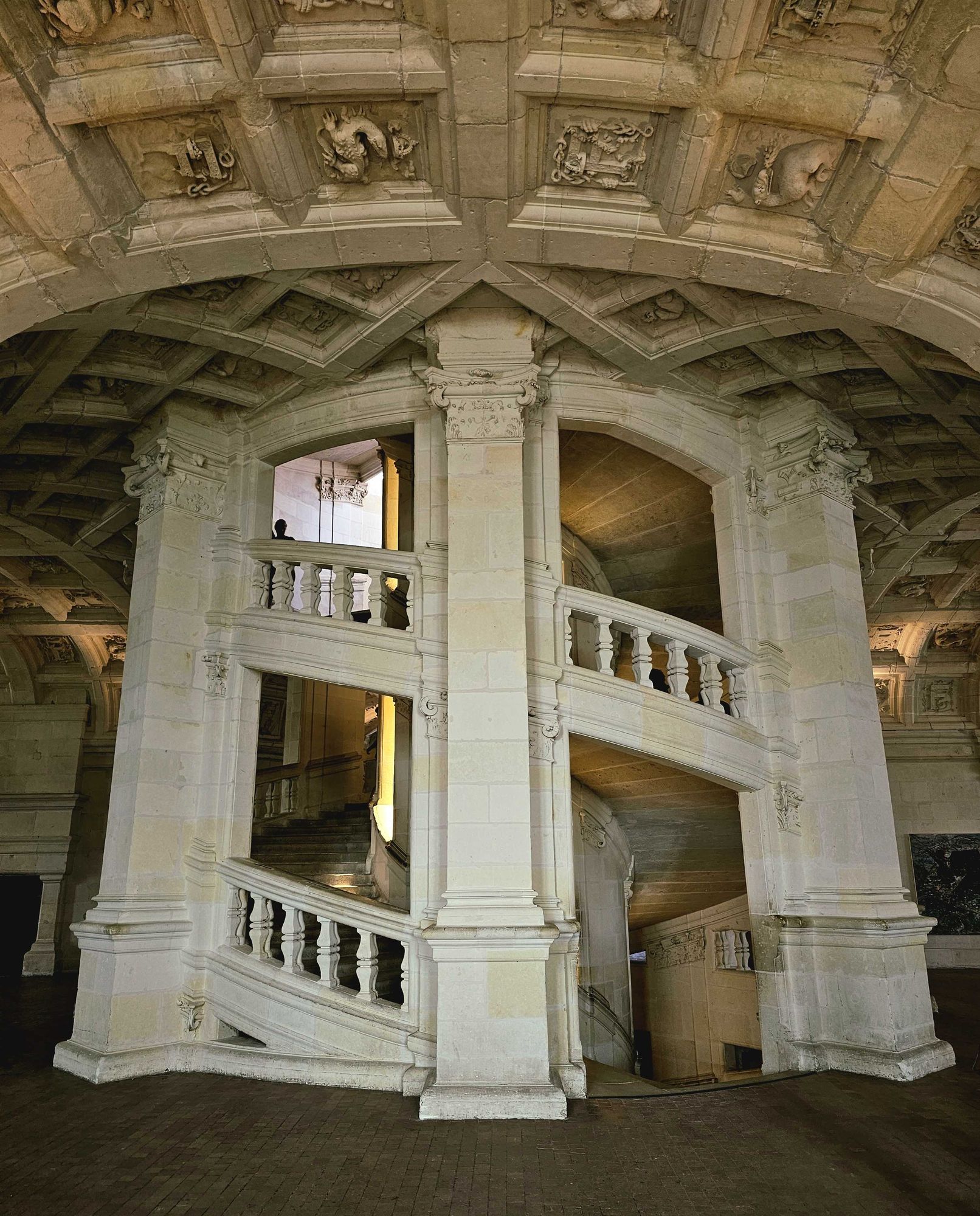 photo of the double helix staircase in Chambord castle, warm lighting