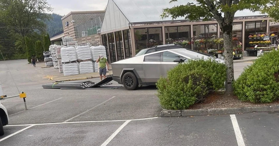 the beams have slid out the back of the cyber truck and are now on the floor. the man is scratching his head, wondering what mystery of physics could have caused this to occur.